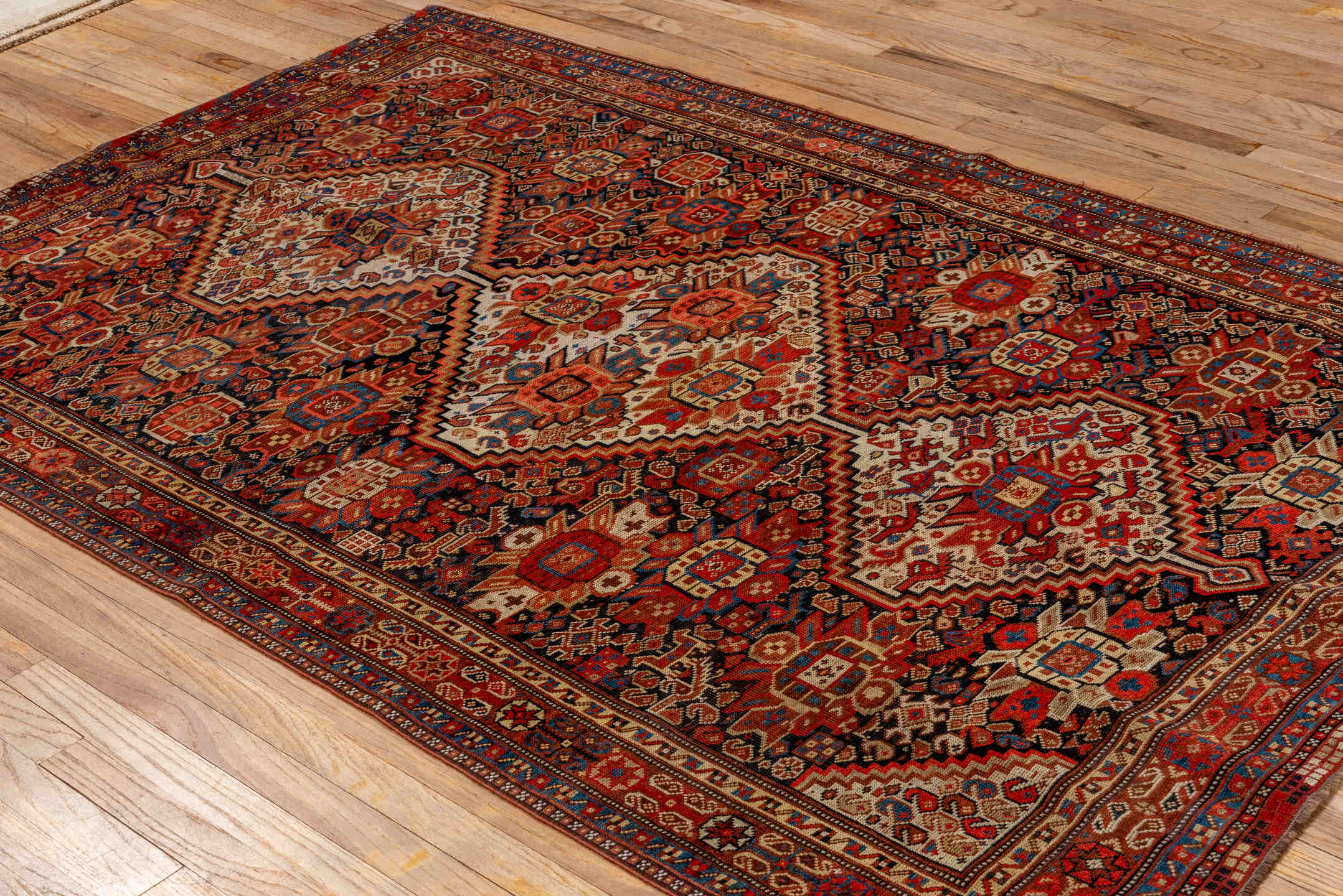 7' x 9' one-of-a-kind handmade vintage Tulu large size rug. Color palette: rust, ivory, navy, crimson, camel, charcoal