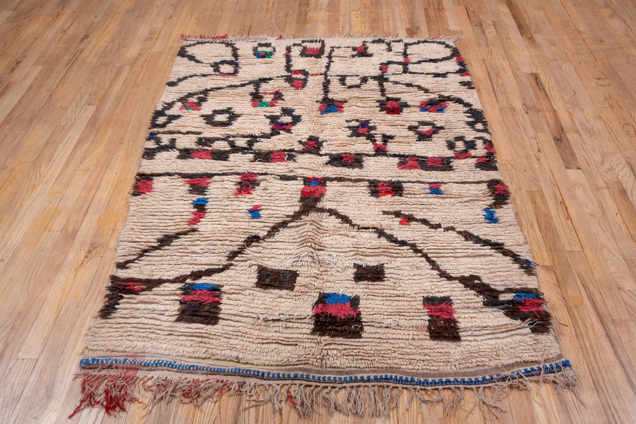 4' x 6' one-of-a-kind handmade vintage Moroccan small size rug. Color palette: ivory, brown, crimson, cobalt, teal, rose
