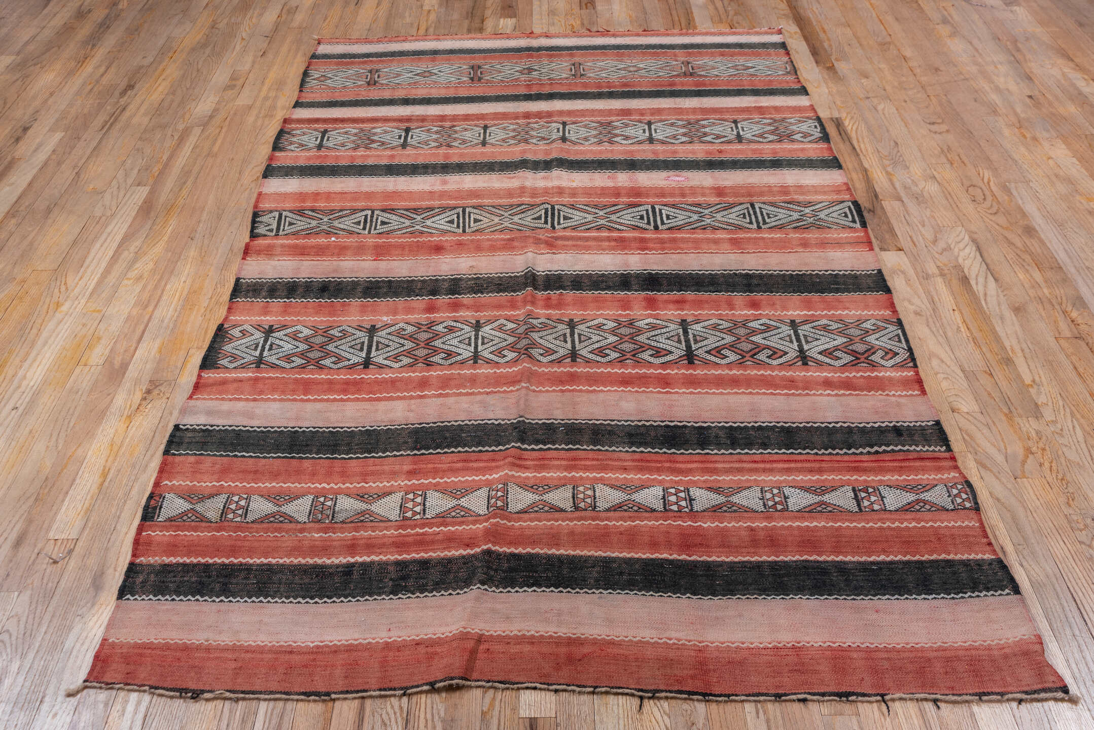 5' x 8' one-of-a-kind handmade vintage Jijim medium size rug. Color palette: black, brown, gray, light gray, orange, pink