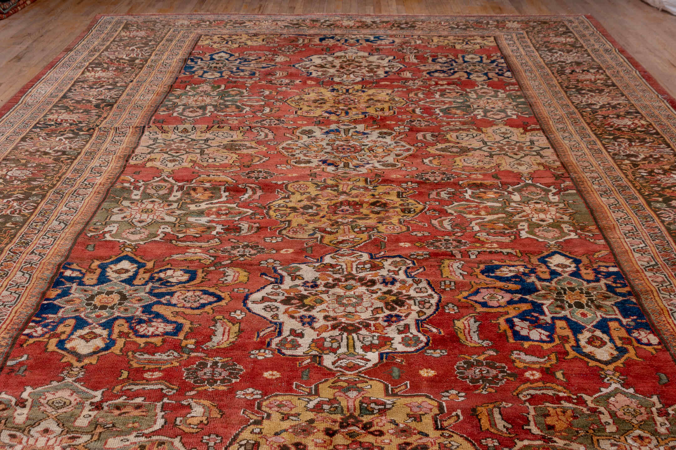 11' x 19' one-of-a-kind handmade antique Sultanabad oversize rug. Color palette: terra cotta, brown, ivory, gold, navy, sage