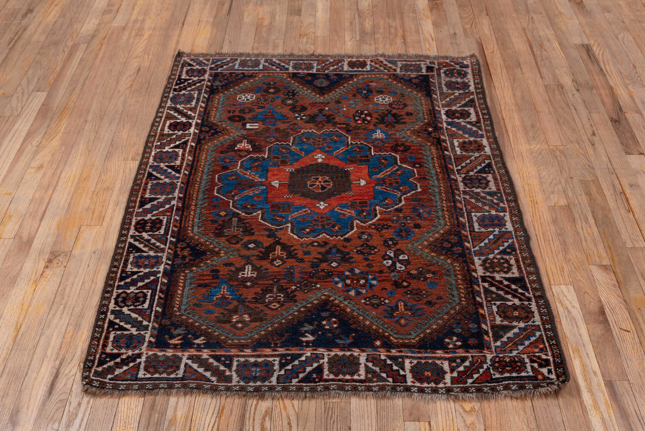 3' x 5' one-of-a-kind handmade antique Shiraz small size rug. Color palette: rust, indigo, ivory, sky blue, brown, charcoal