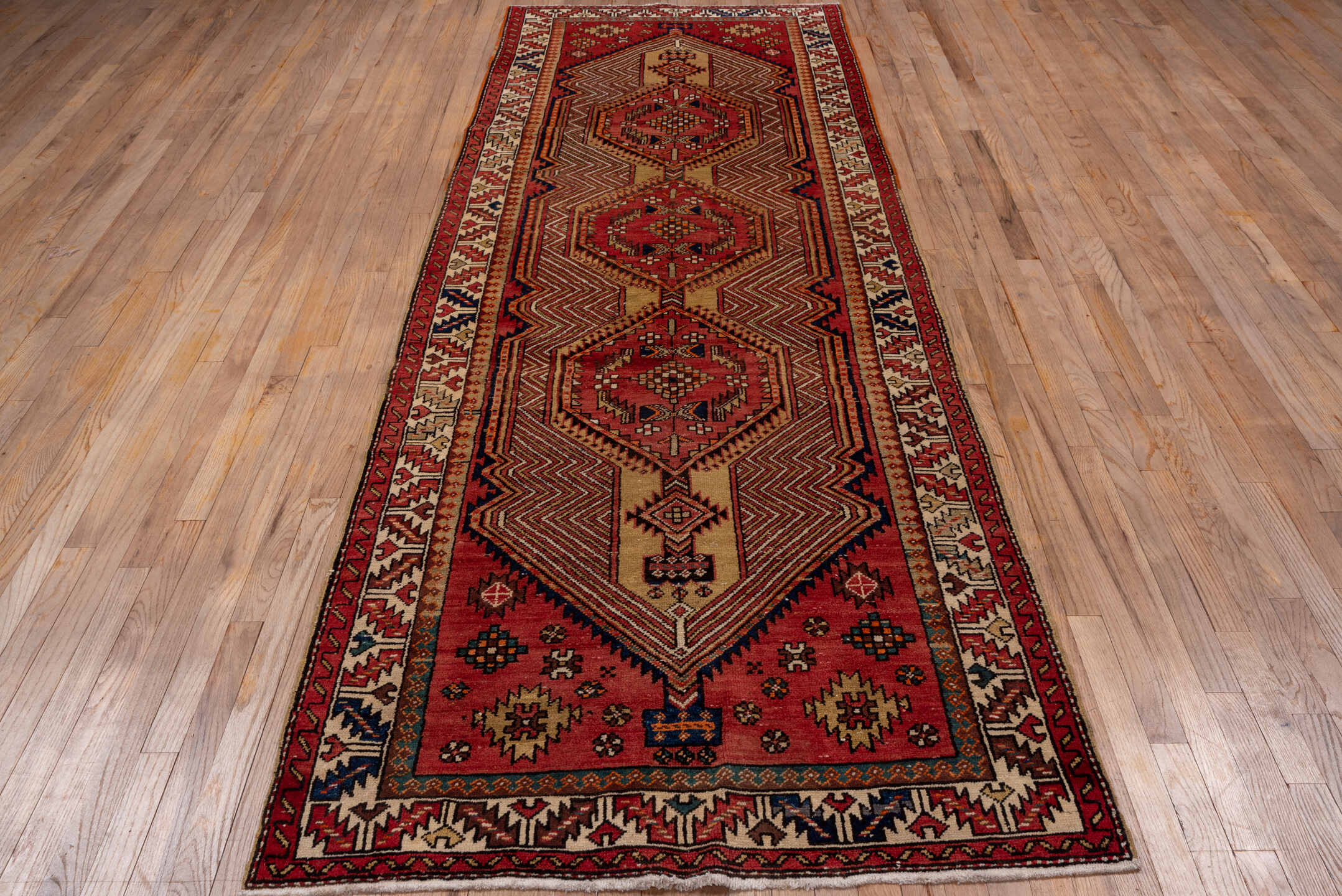 4' x 11' one-of-a-kind handmade antique Sarab runner rug. Color palette: rust, ivory, brick, navy, camel, burgundy