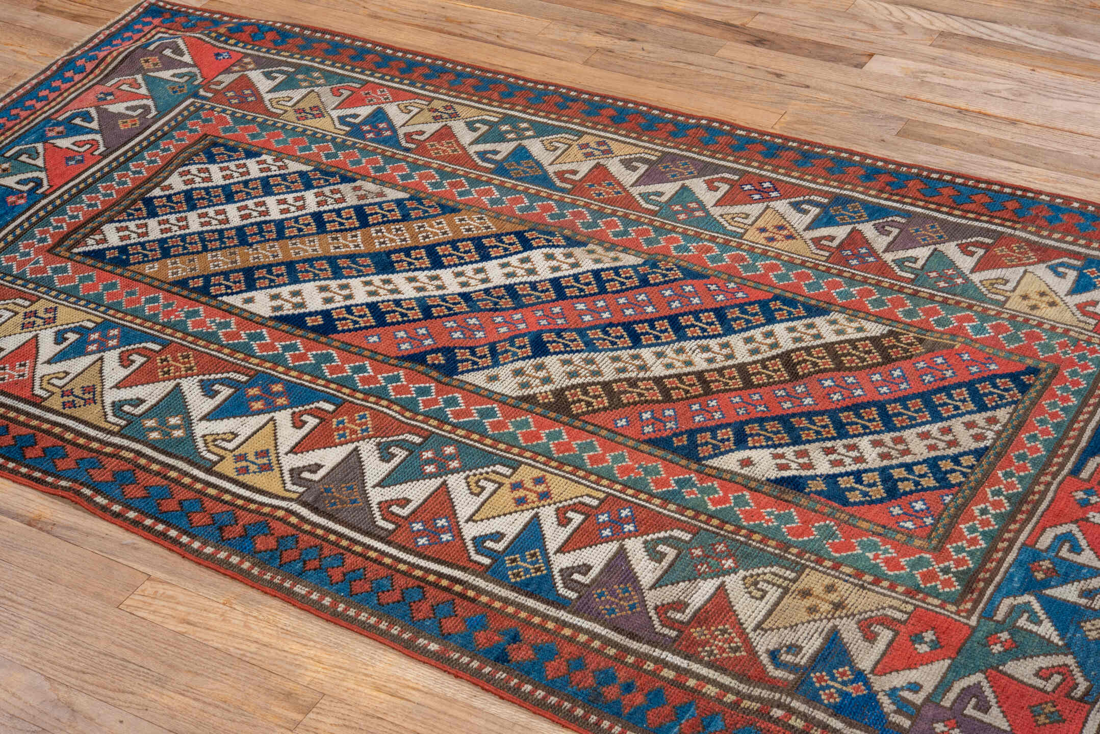 3' x 6' one-of-a-kind handmade antique Kazak small size rug. Color palette: ivory, navy, turquoise, rust, camel, terracotta