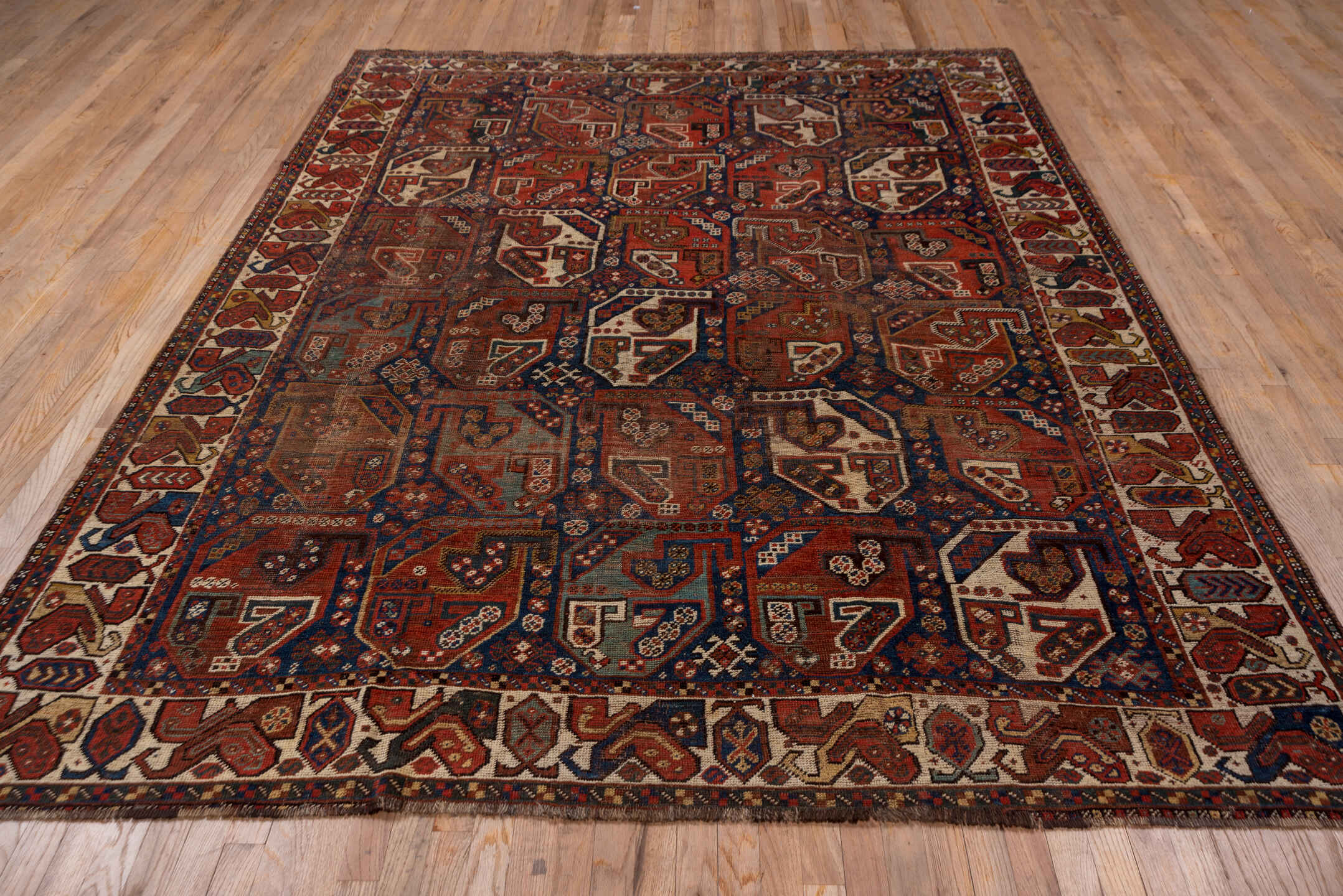 7' x 9' one-of-a-kind handmade antique Shiraz rug. Color palette: rust, indigo, ivory, brick, camel, navy, brown, terracotta