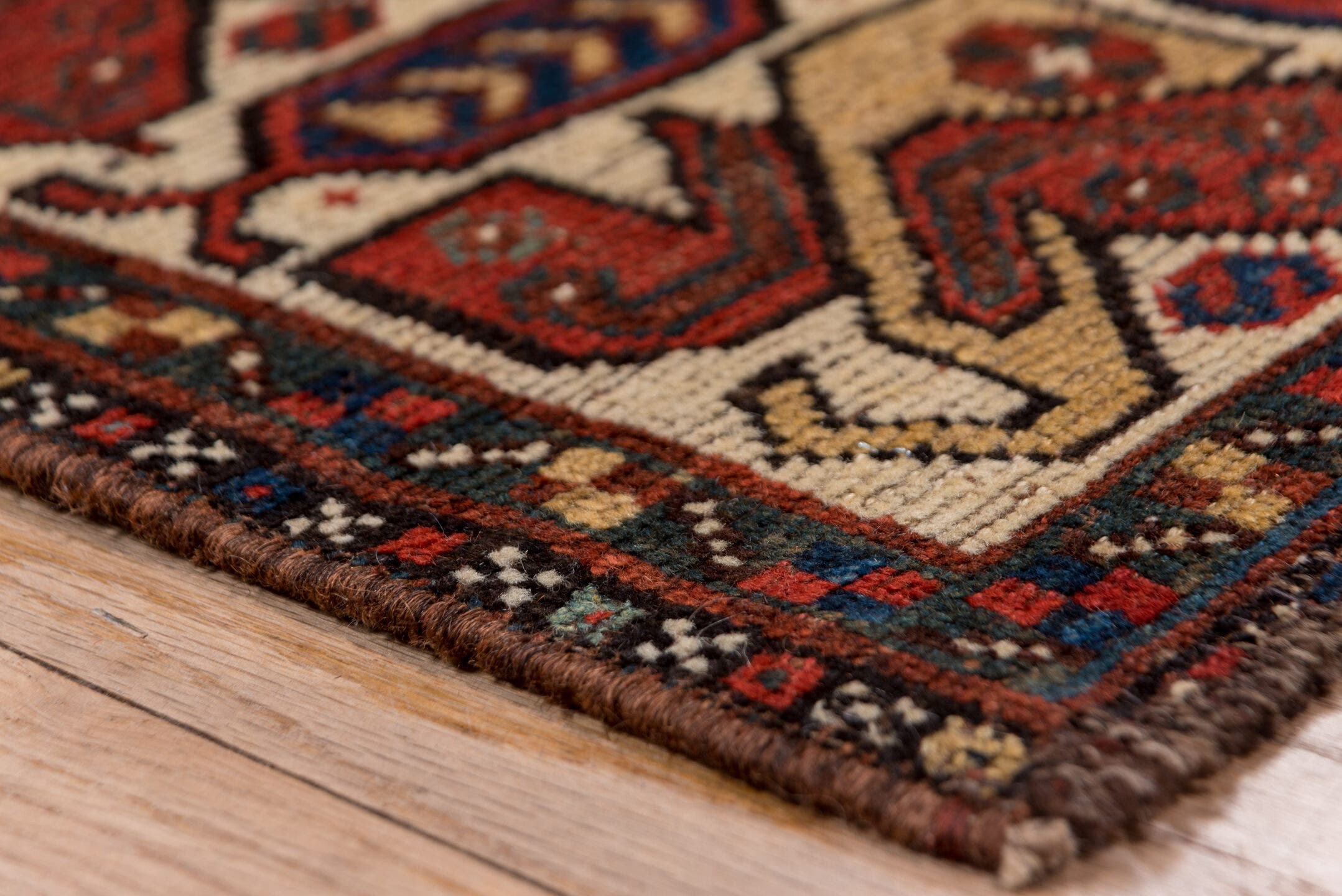 7' x 9' one-of-a-kind handmade antique Shiraz rug. Color palette: rust, indigo, ivory, brick, camel, navy, brown, terracotta
