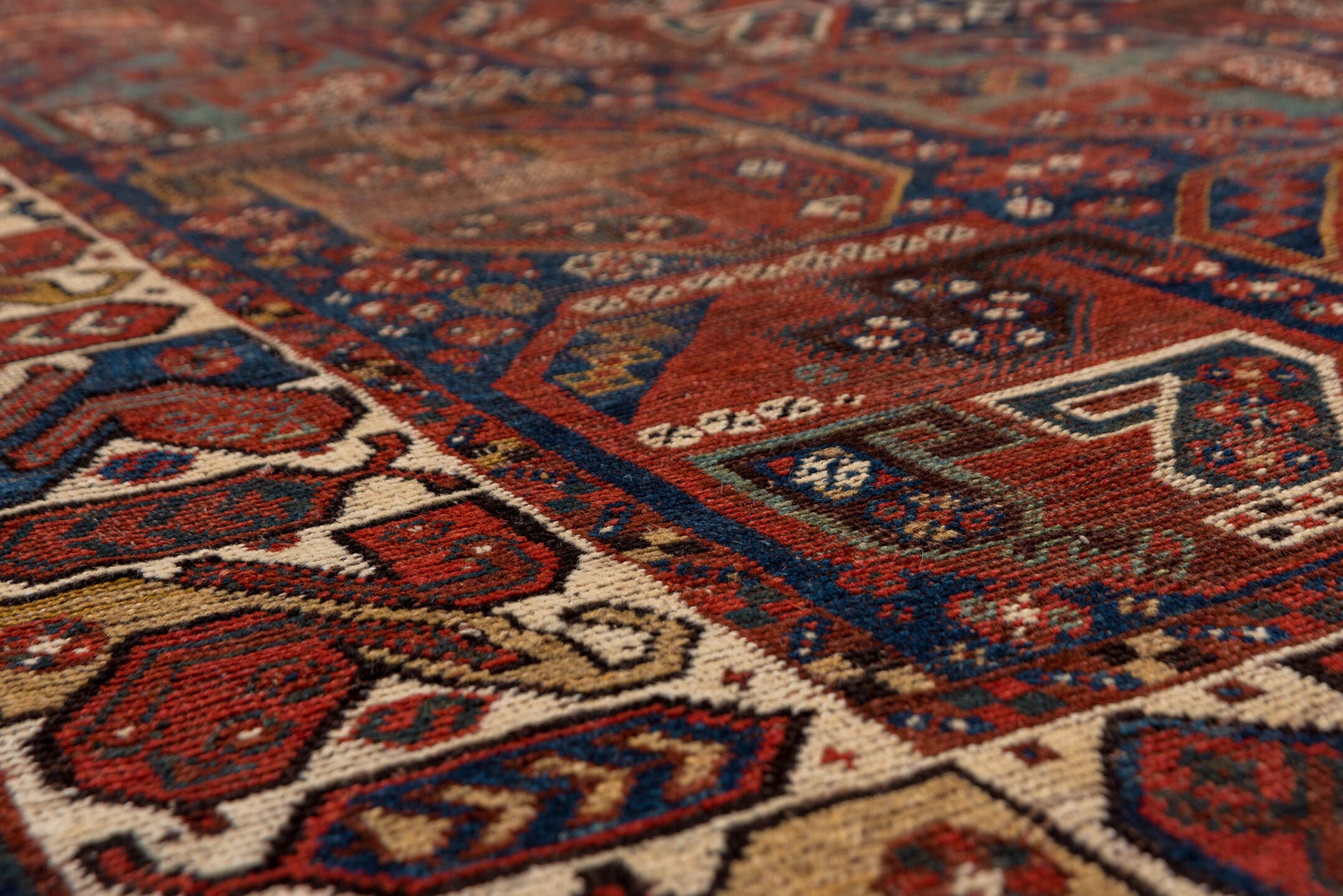7' x 9' one-of-a-kind handmade antique Shiraz rug. Color palette: rust, indigo, ivory, brick, camel, navy, brown, terracotta