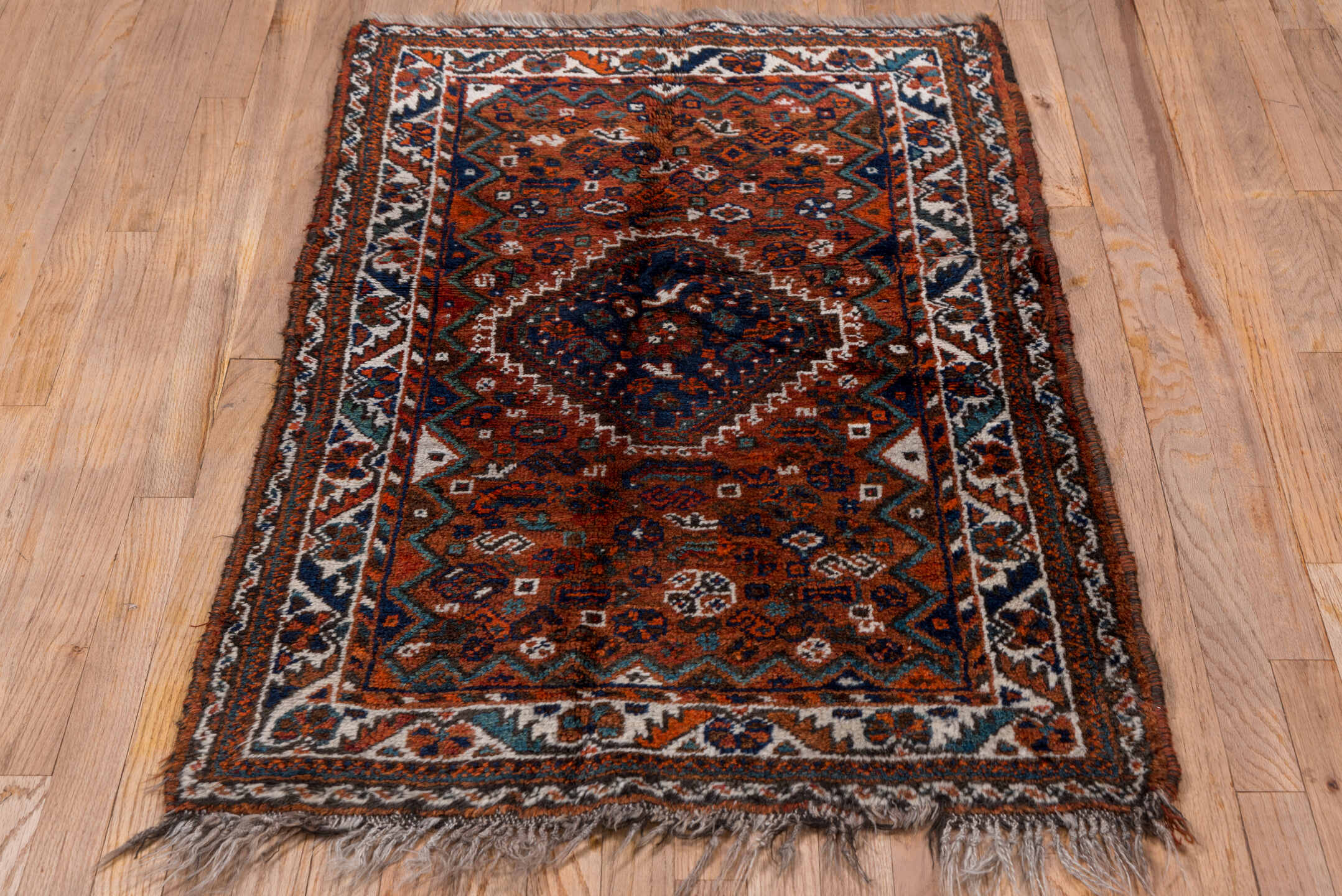2' x 4' one-of-a-kind handmade antique Shiraz small size rug. Color palette: rust, indigo, ivory, terra cotta, teal