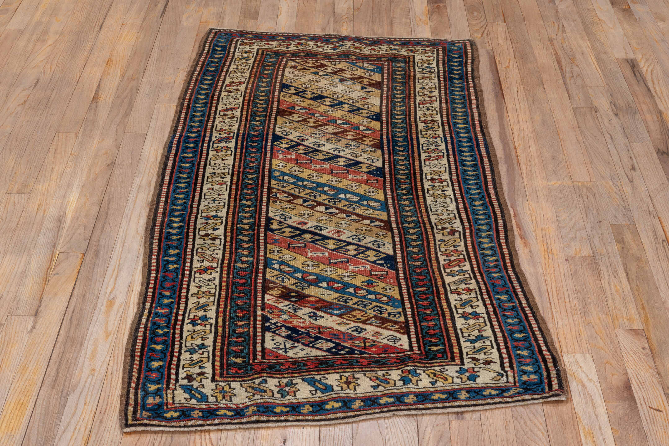2' x 5' one-of-a-kind handmade antique Caucasian small size rug. Color palette: ivory, navy, rust, sky blue, brown, red