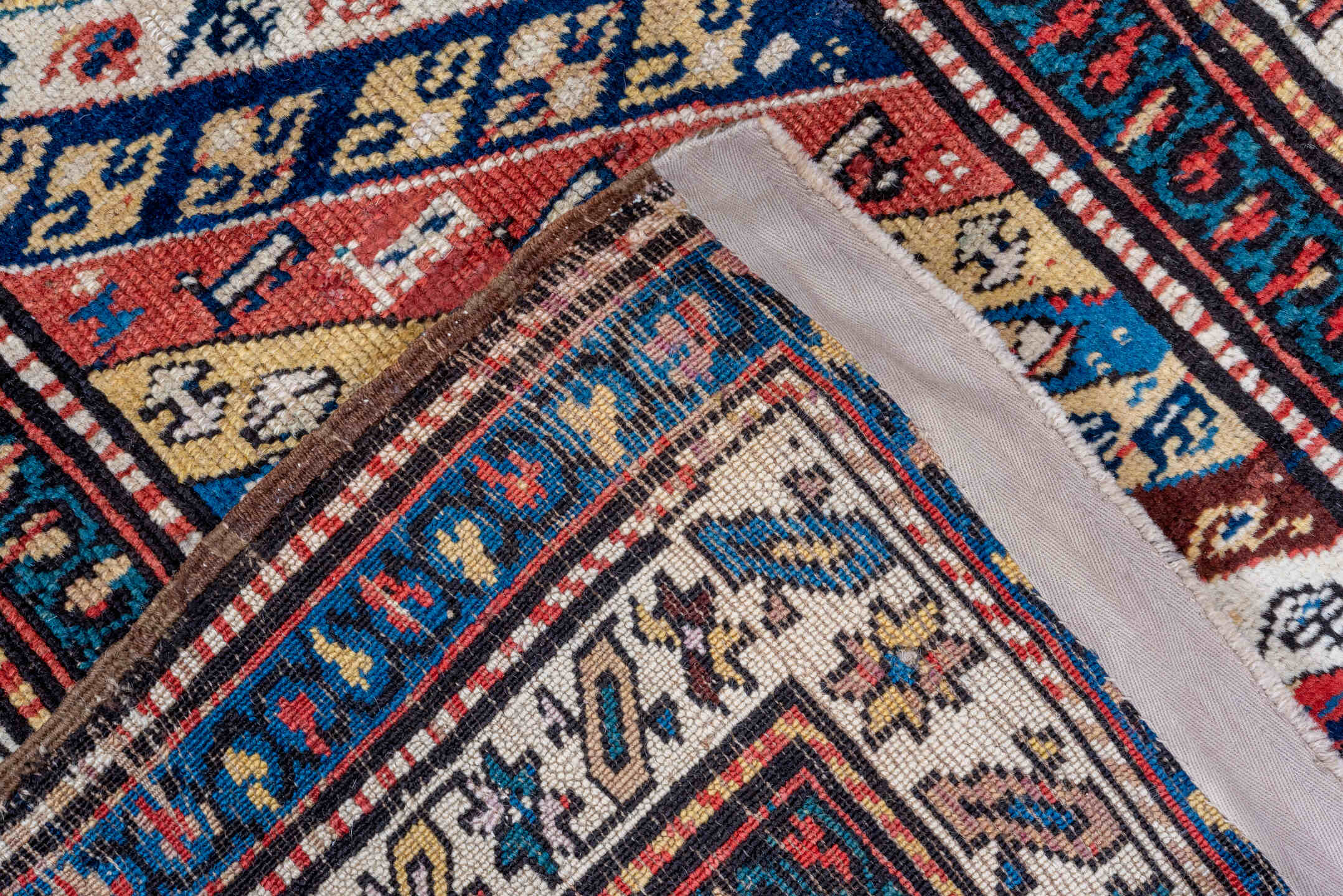 2' x 5' one-of-a-kind handmade antique Caucasian small size rug. Color palette: ivory, navy, rust, sky blue, brown, red