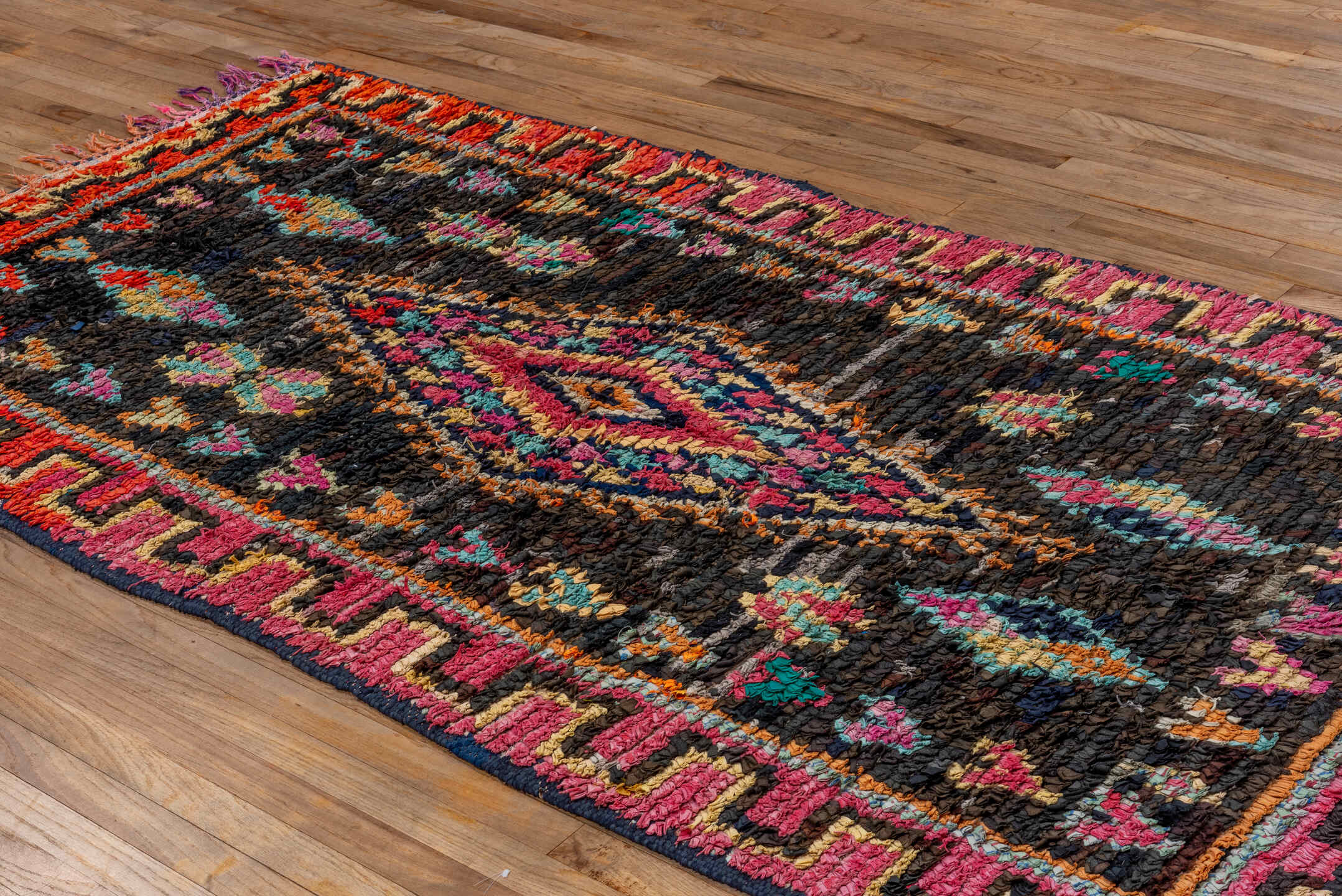 4' x 8' one-of-a-kind handmade vintage Rag Rug rug. Color palette: charcoal, hot pink, orange, turquoise, gold, cream, black
