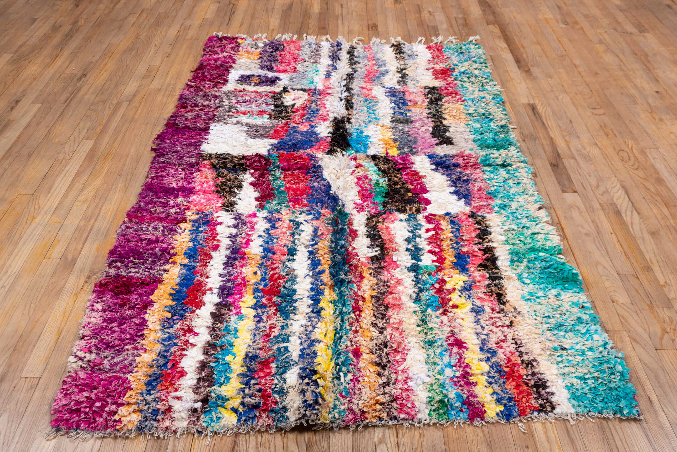 4' x 8' one-of-a-kind handmade vintage Rag Rug rug. Color palette: ivory, magenta, turquoise, cobalt, black, rose, lavender