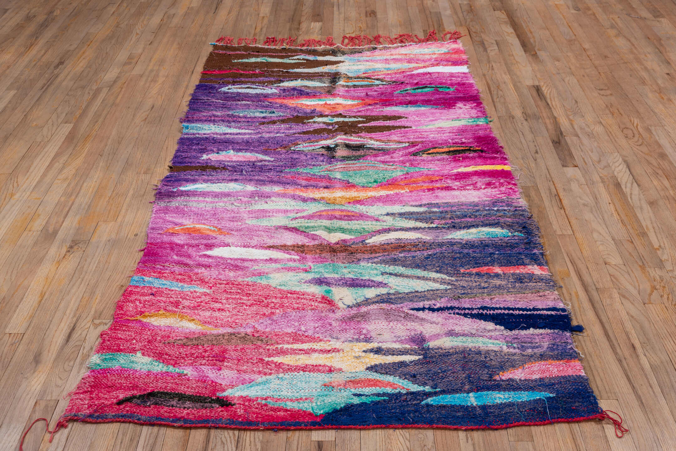 4' x 7' one-of-a-kind handmade vintage Rag Rug rug. Color palette: magenta, purple, pink, brown, turquoise, ivory, navy