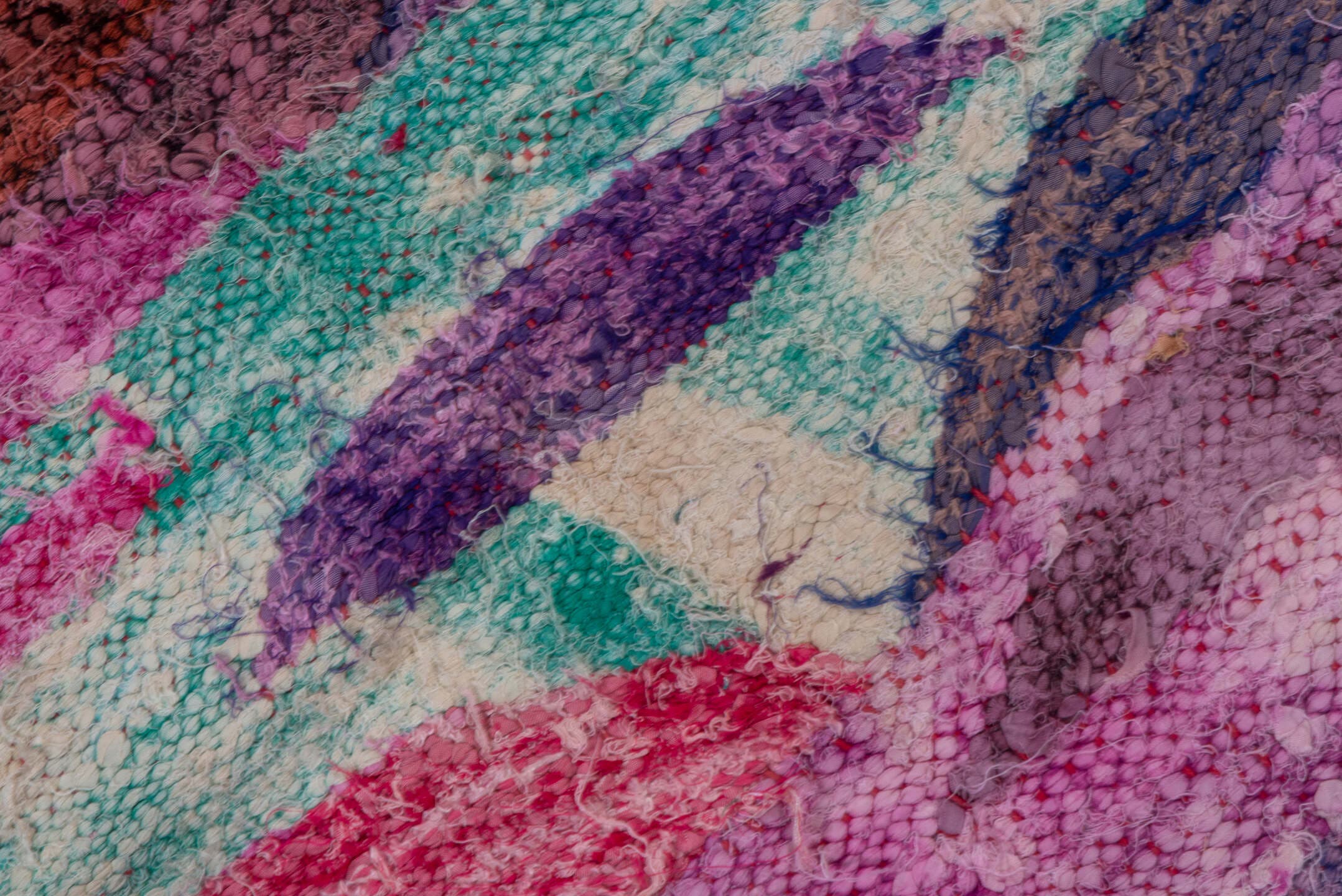 4' x 7' one-of-a-kind handmade vintage Rag Rug rug. Color palette: magenta, purple, pink, brown, turquoise, ivory, navy