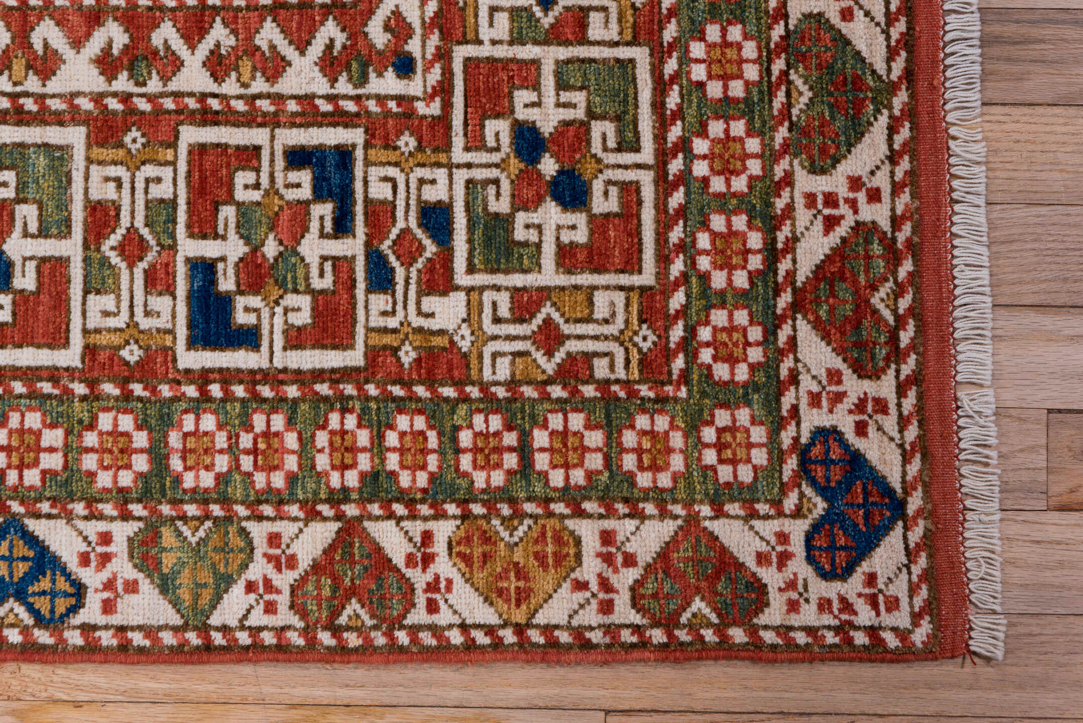 4' x 7' one-of-a-kind handmade vintage Kazak rug. Color palette: ivory, rust, indigo, olive, gold, terra cotta, terracotta