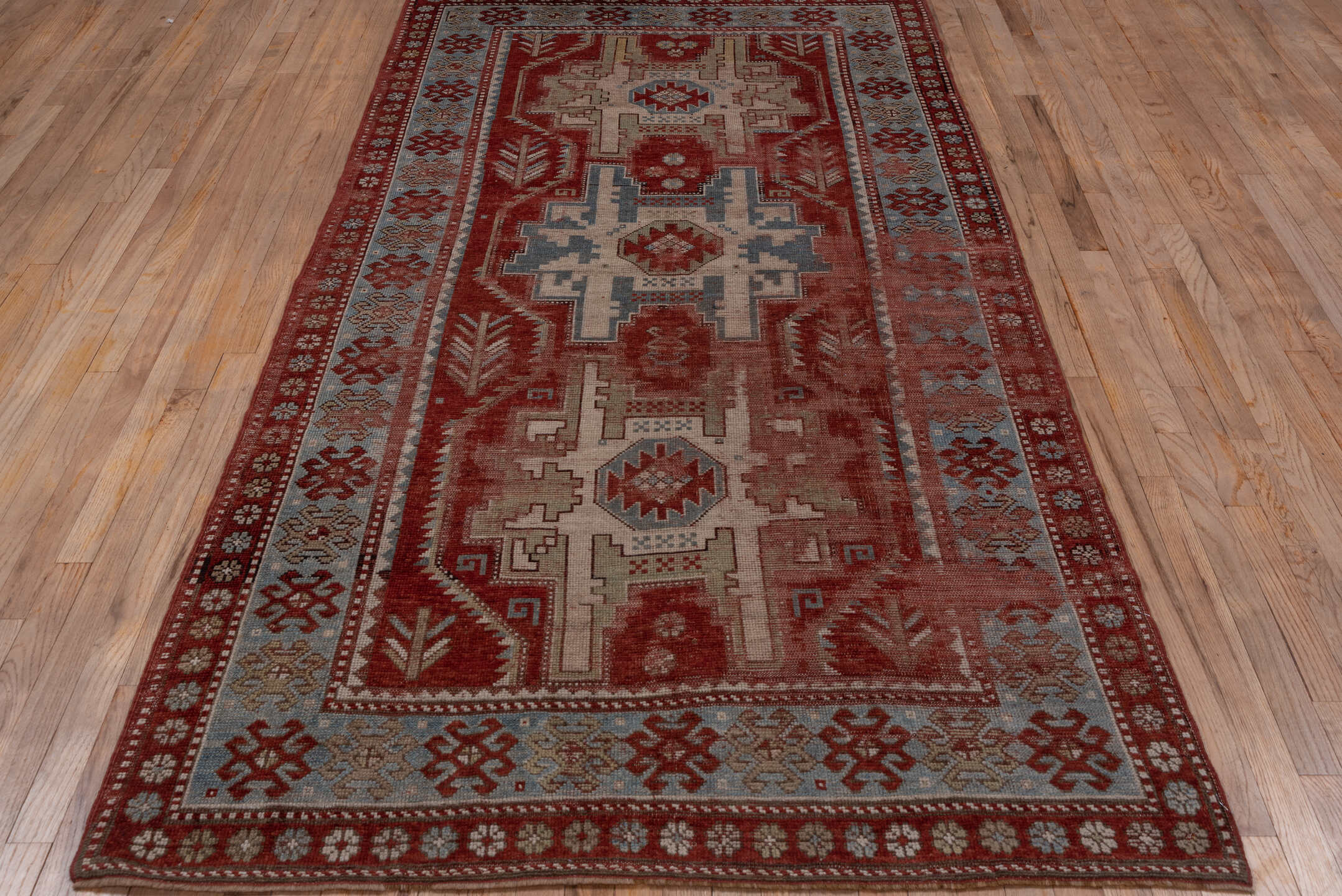 4' x 9' one-of-a-kind handmade antique Kazak runner rug. Color palette: rust, ivory, soft blue, brick, taupe, burgundy