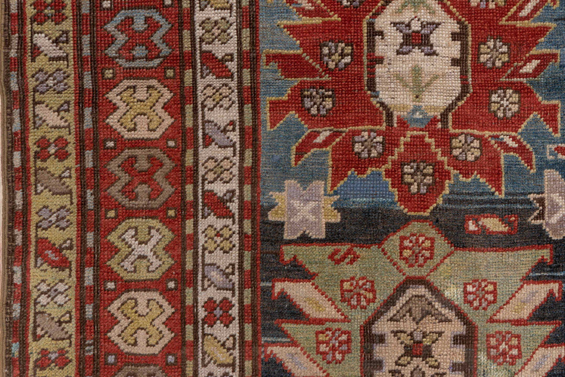4' x 8' one-of-a-kind handmade antique Caucasian rug. Color palette: ivory, rust, brick, slate, sky_blue, camel, charcoal