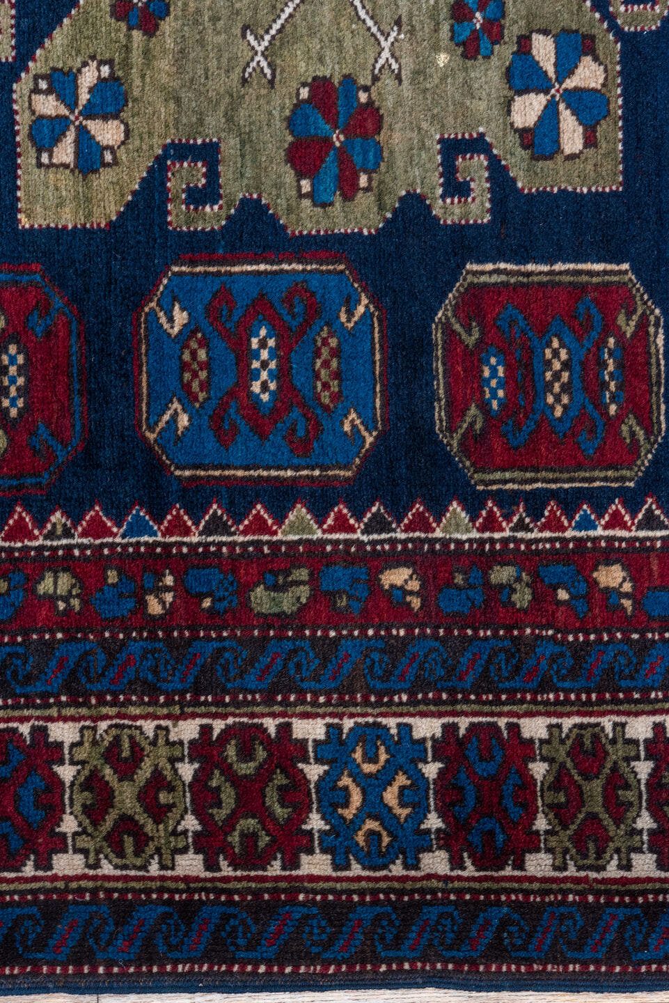 4' x 7' one-of-a-kind handmade antique Caucasian rug. Color palette: navy, crimson, ivory, cobalt, burgundy, camel, saffron