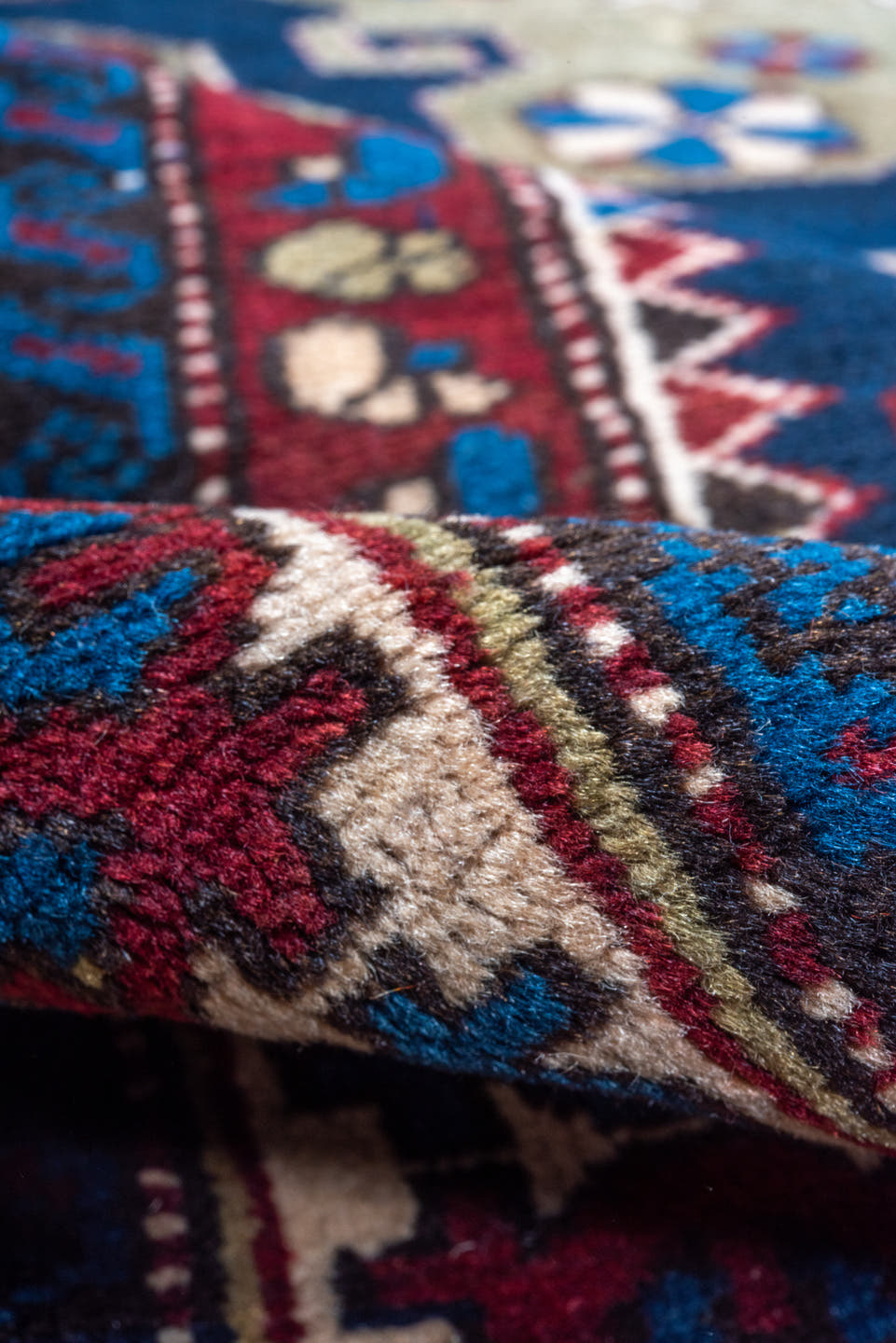 4' x 7' one-of-a-kind handmade antique Caucasian rug. Color palette: navy, crimson, ivory, cobalt, burgundy, camel, saffron