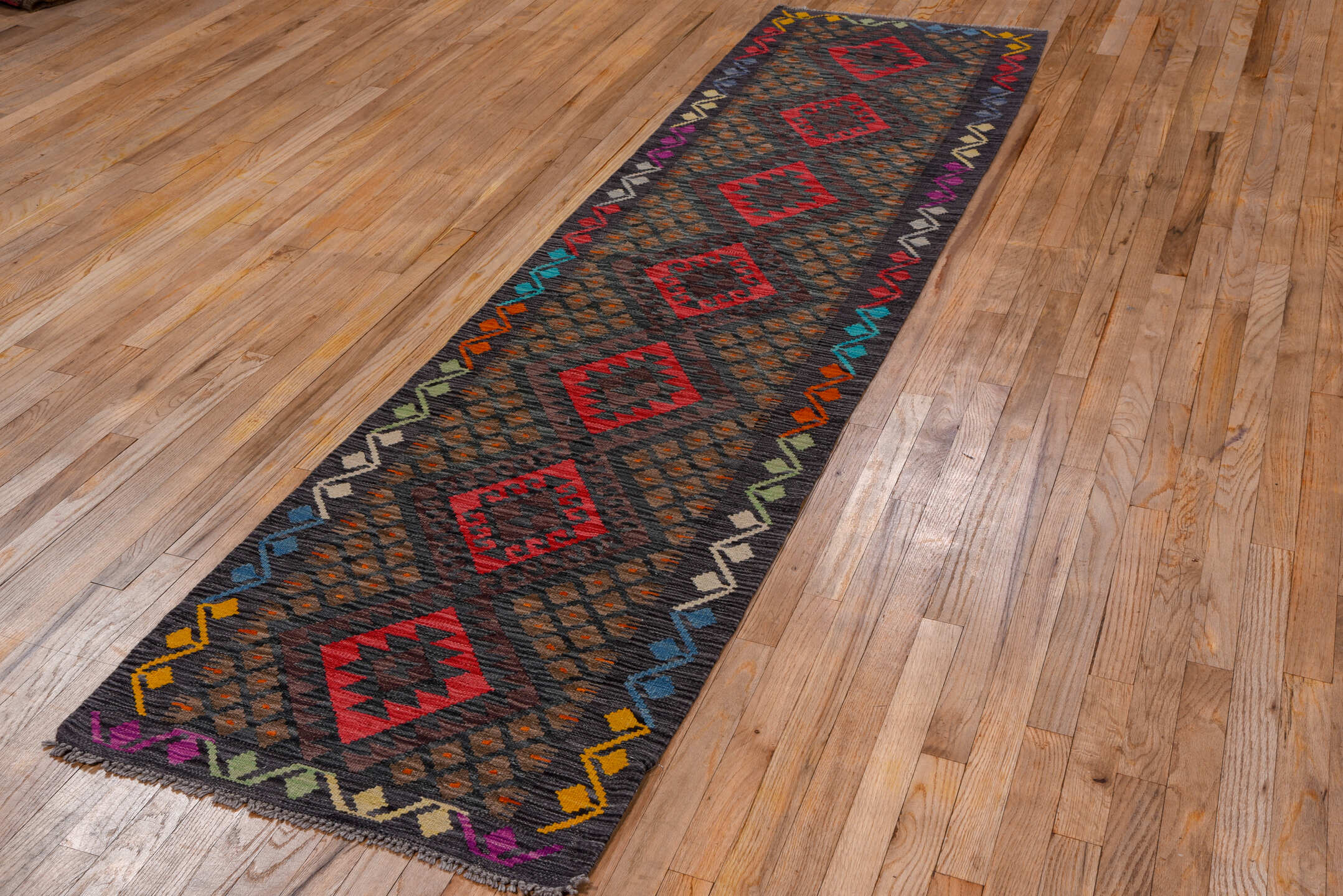 2' x 9' one-of-a-kind handmade vintage Kilim runner rug. Color palette: charcoal, crimson, rust, turquoise, ivory, gold