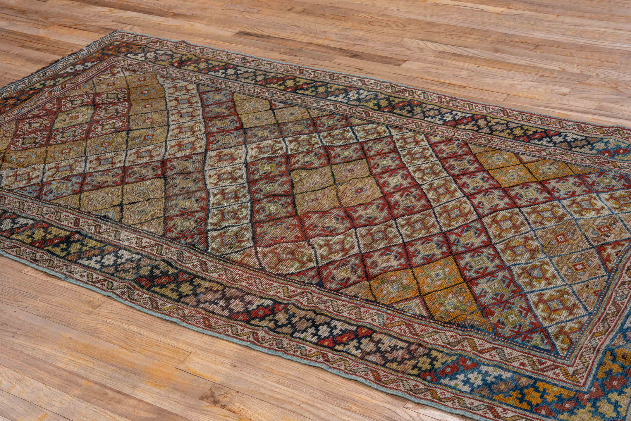 4' x 8' one-of-a-kind handmade antique Kurd rug. Color palette: camel, ivory, rust, sky blue, navy, taupe, gold, brown