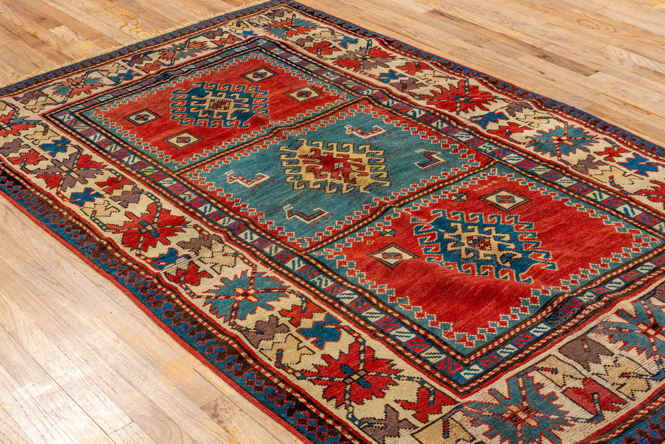 4' x 7' one-of-a-kind handmade antique Kazak rug. Color palette: ivory, red, sky blue, navy, rust, taupe, teal, light blue