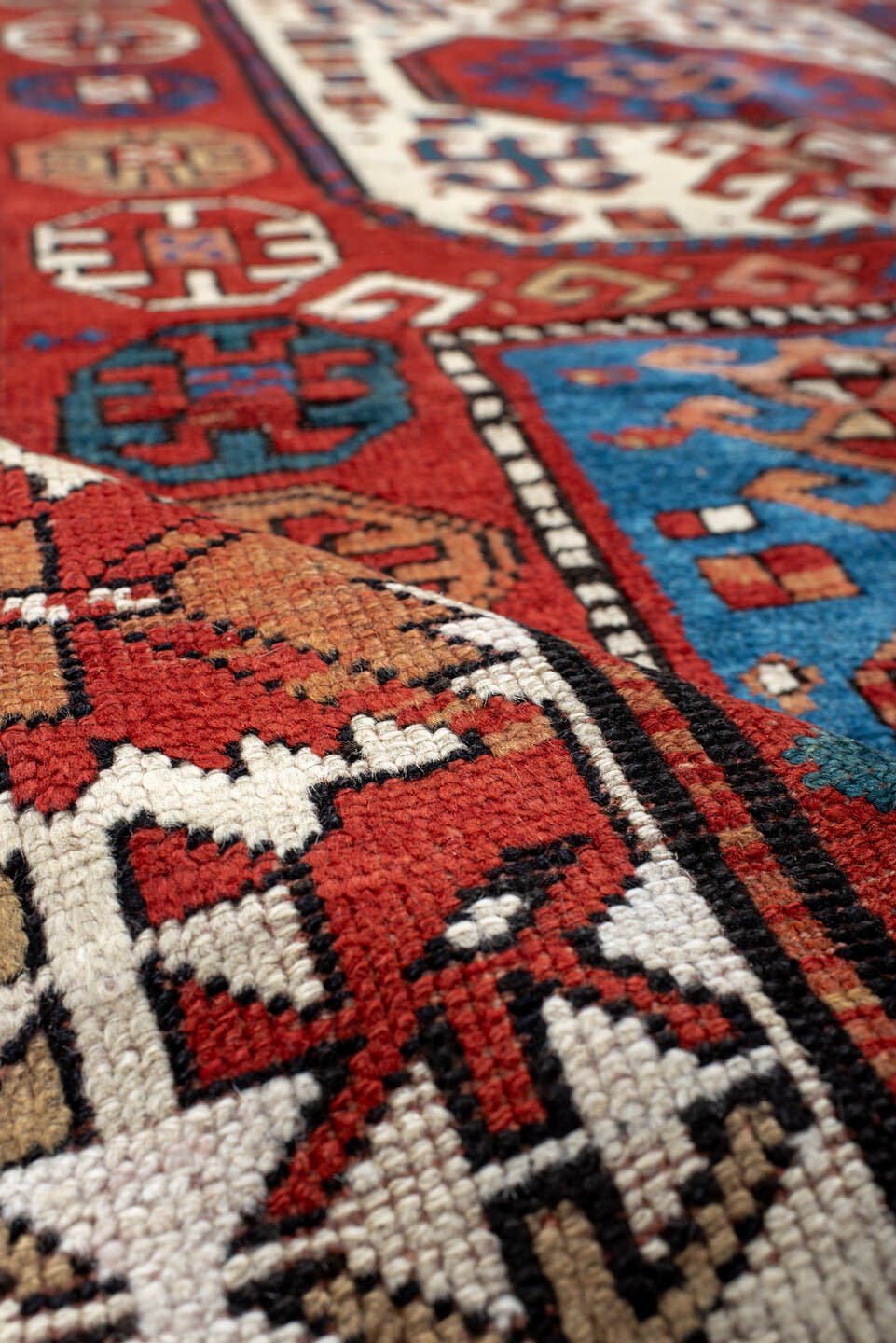 5' x 10' one-of-a-kind handmade antique Kazak medium size rug. Color palette: red, ivory, blue, teal, navy, rust, cream