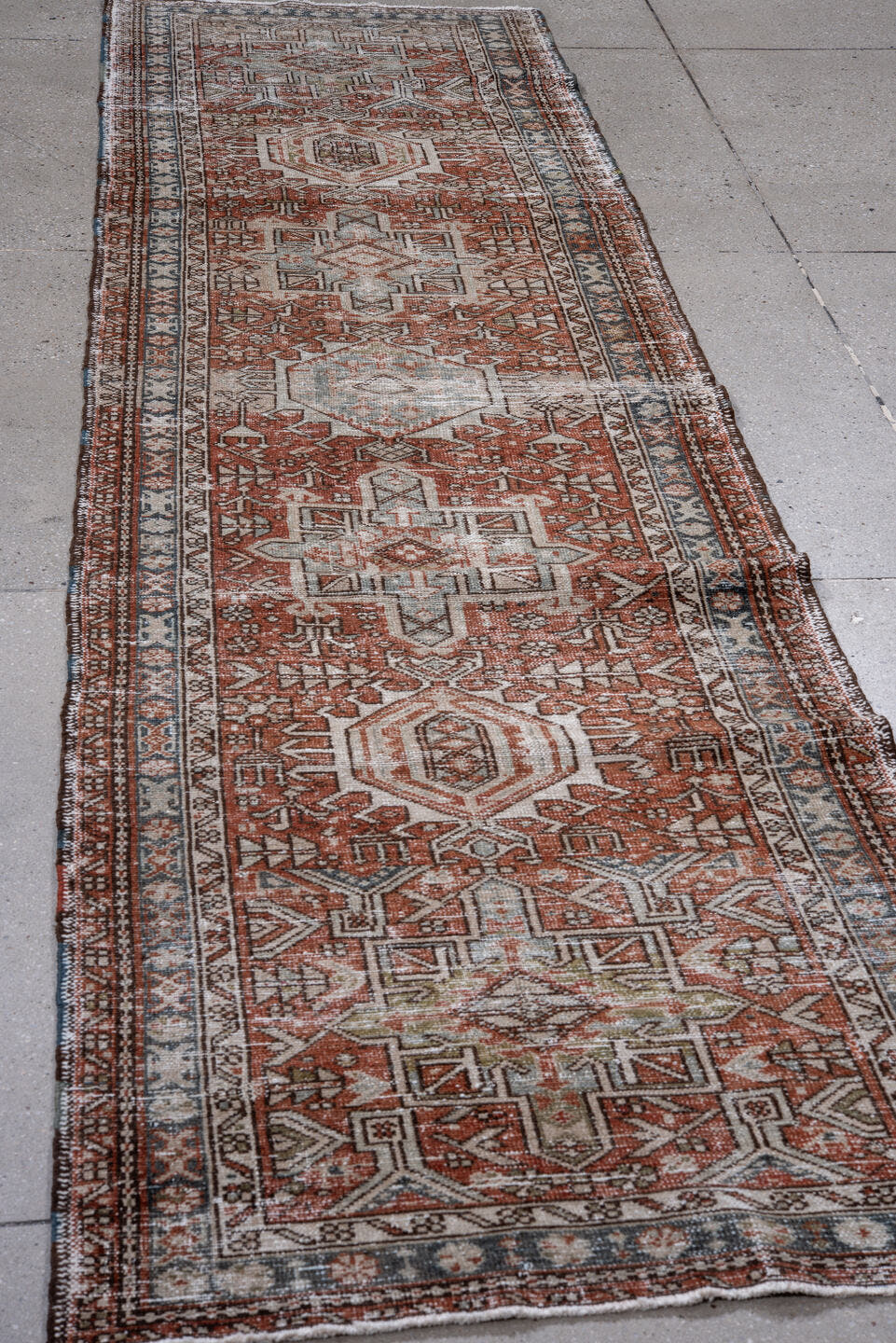 2' x 10' one-of-a-kind handmade antique Karaje runner rug. Color palette: rust, ivory, blue, brown, taupe, sage, terracotta