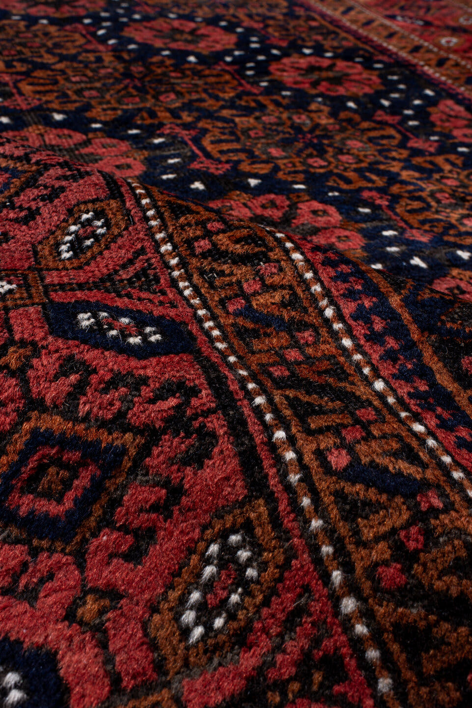 3' x 7' one-of-a-kind handmade antique Belouch rug. Color palette: rust, navy, terracotta, burgundy, camel, ivory, charcoal
