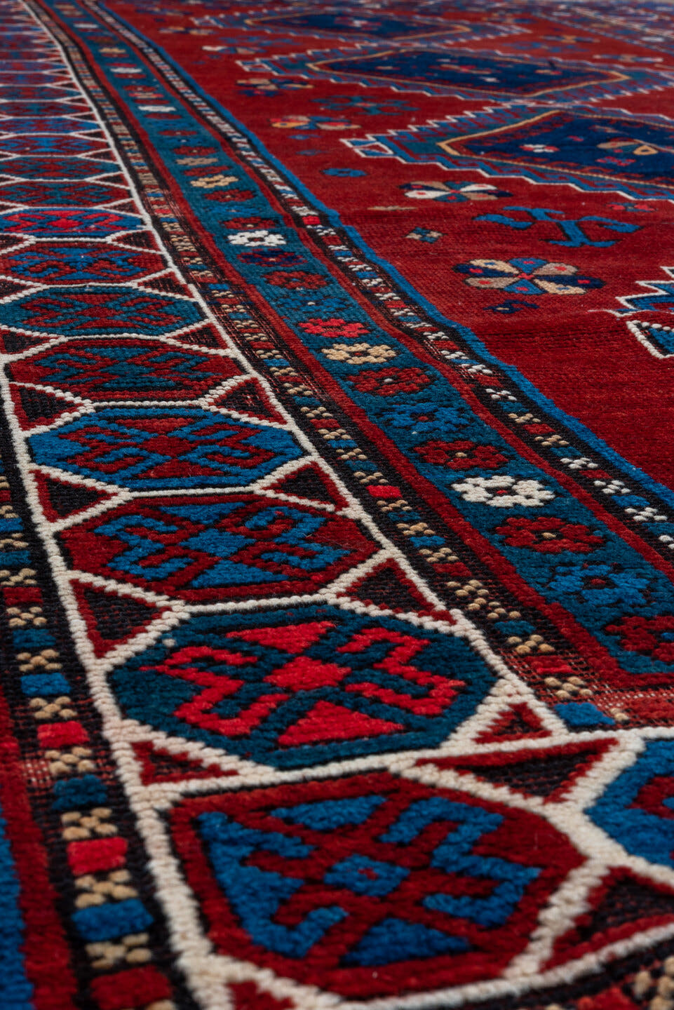4' x 10' one-of-a-kind handmade antique Kazak runner rug. Color palette: red, navy, sky blue, ivory, crimson, charcoal, rose