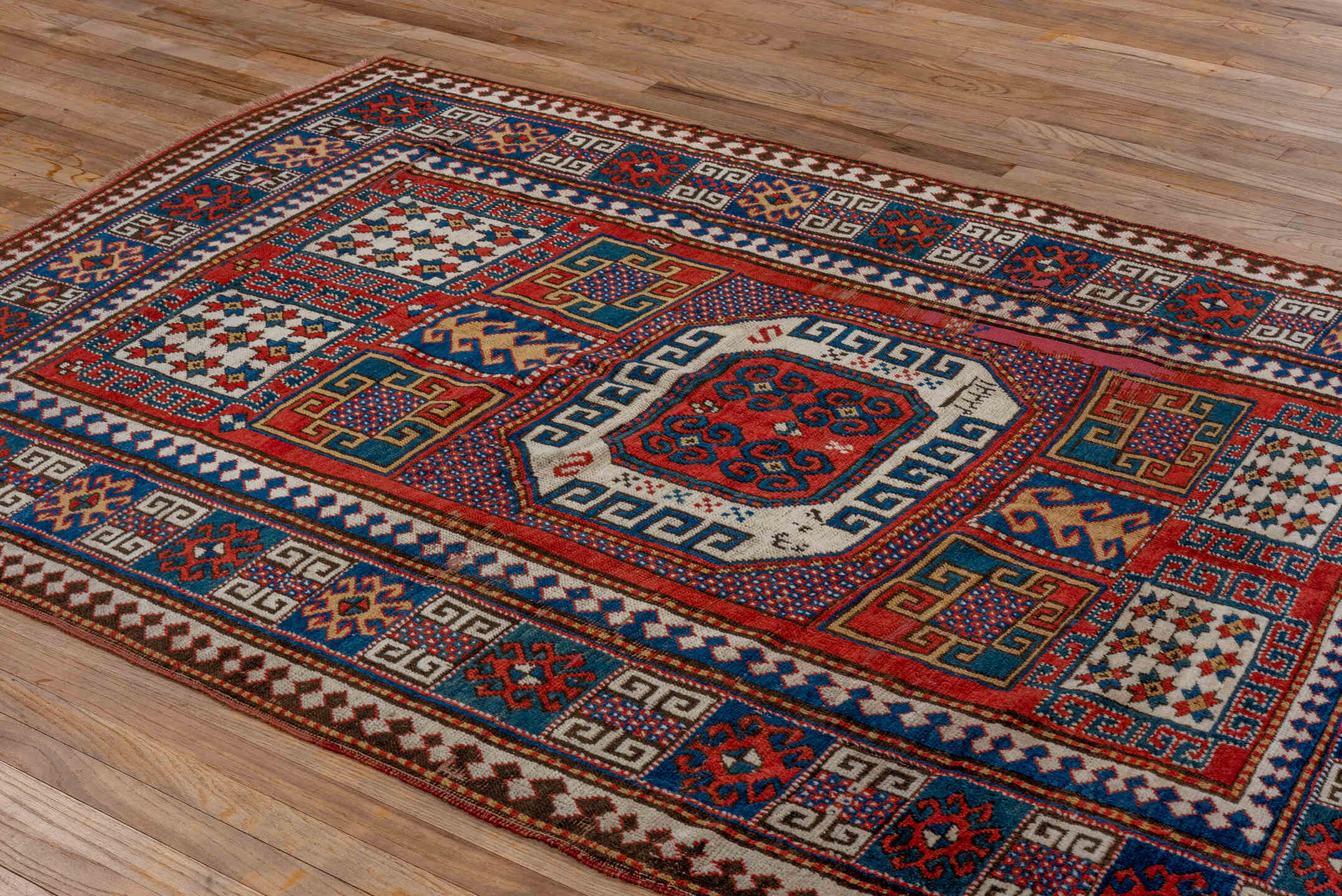 5' x 7' one-of-a-kind handmade vintage Kazak rug. Color palette: blue, brown, gray, pink, red