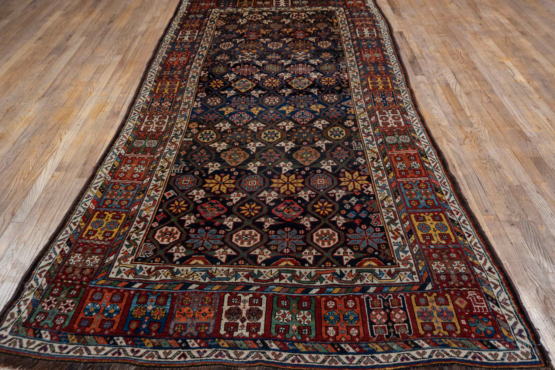 5' x 11' one-of-a-kind handmade vintage Baktiary rug. Color palette: black, blue, brown, gray, orange, pink, red