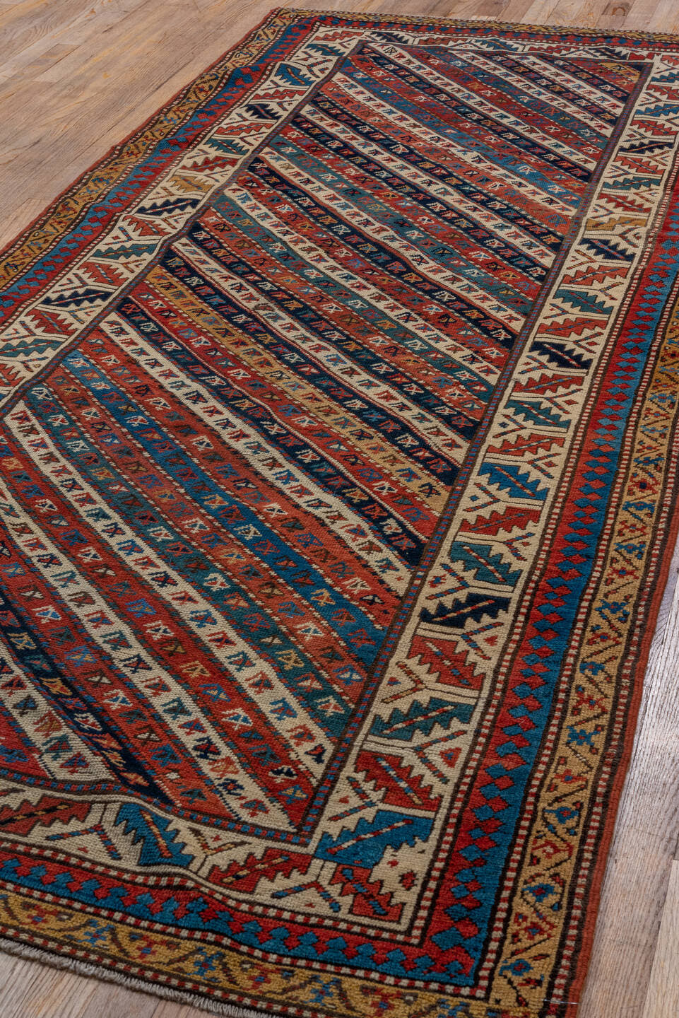 4' x 9' one-of-a-kind handmade antique Kazak runner rug. Color palette: rust, ivory, blue, navy, camel, crimson, charcoal