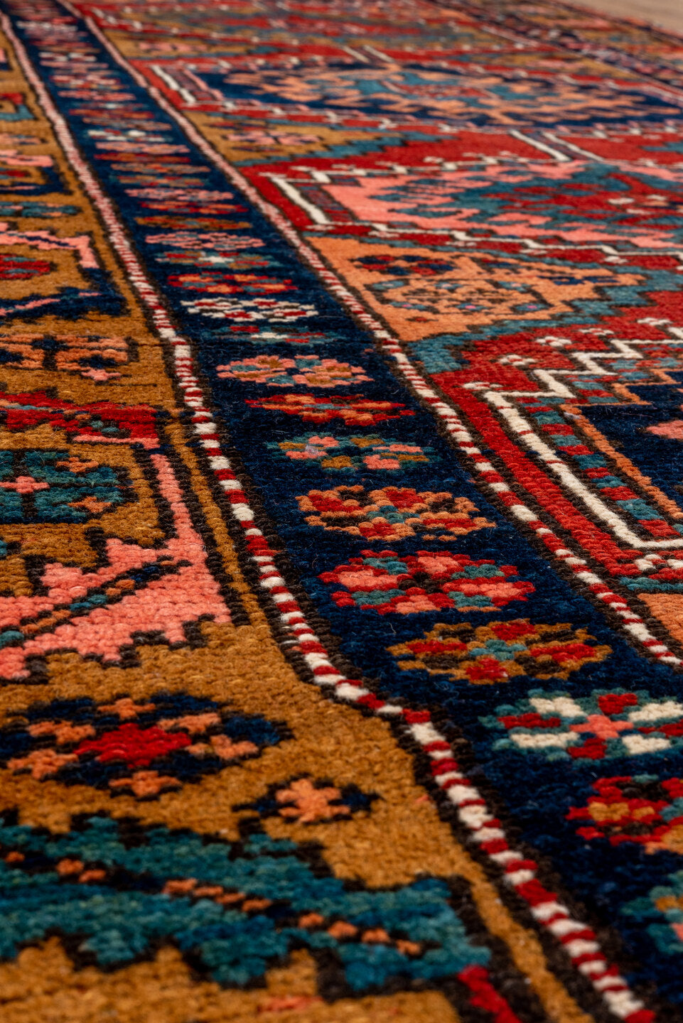 3' x 12' one-of-a-kind handmade vintage Heriz runner rug. Color palette: black, blue, brown, gray, maroon, pink, red