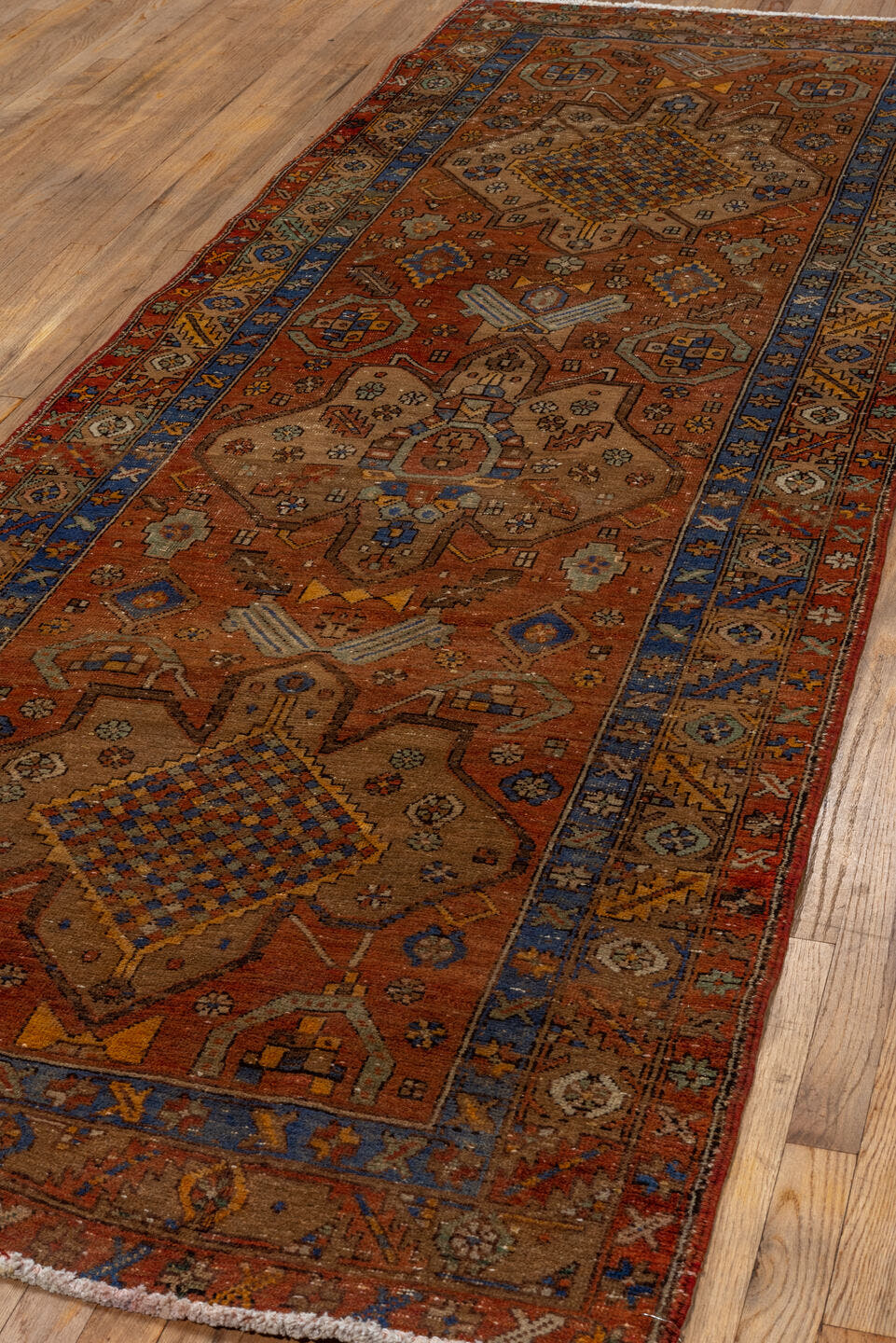 3' x 10' one-of-a-kind handmade vintage Heriz runner rug. Color palette: rust, camel, cobalt, ivory, gold, taupe, brown