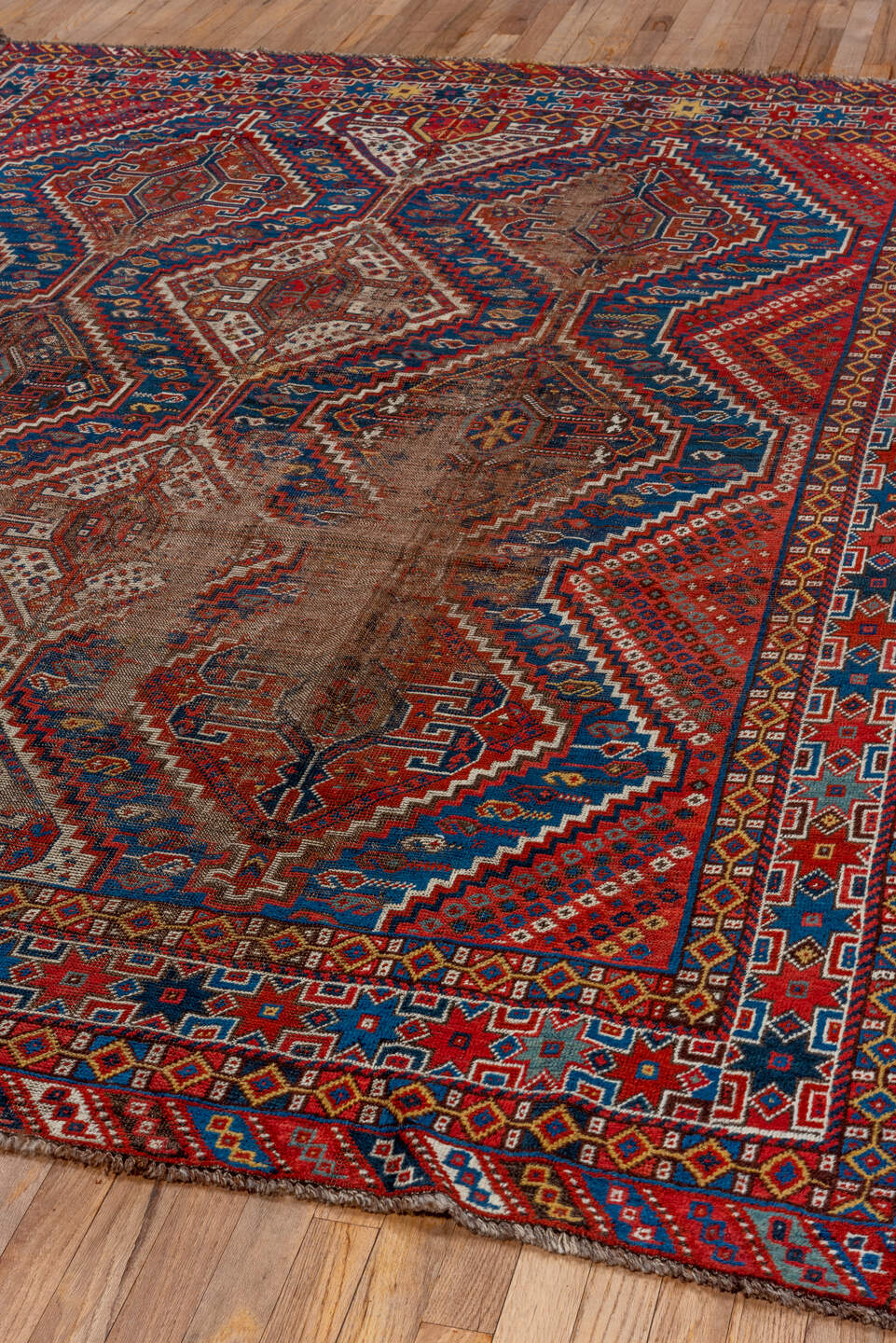 7' x 9' one-of-a-kind handmade vintage Shiraz rug. Color palette: rust, indigo, camel, ivory, crimson, navy, gold, brown