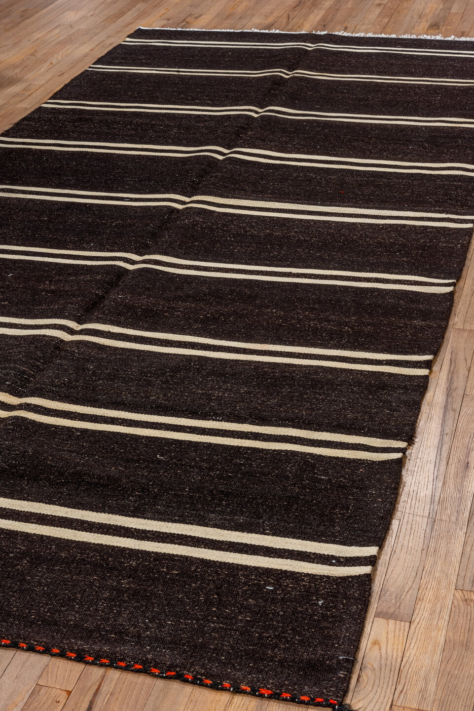 5' x 11' one-of-a-kind handmade vintage  rug. Color palette: black, brown, gray, off-white, orange, red