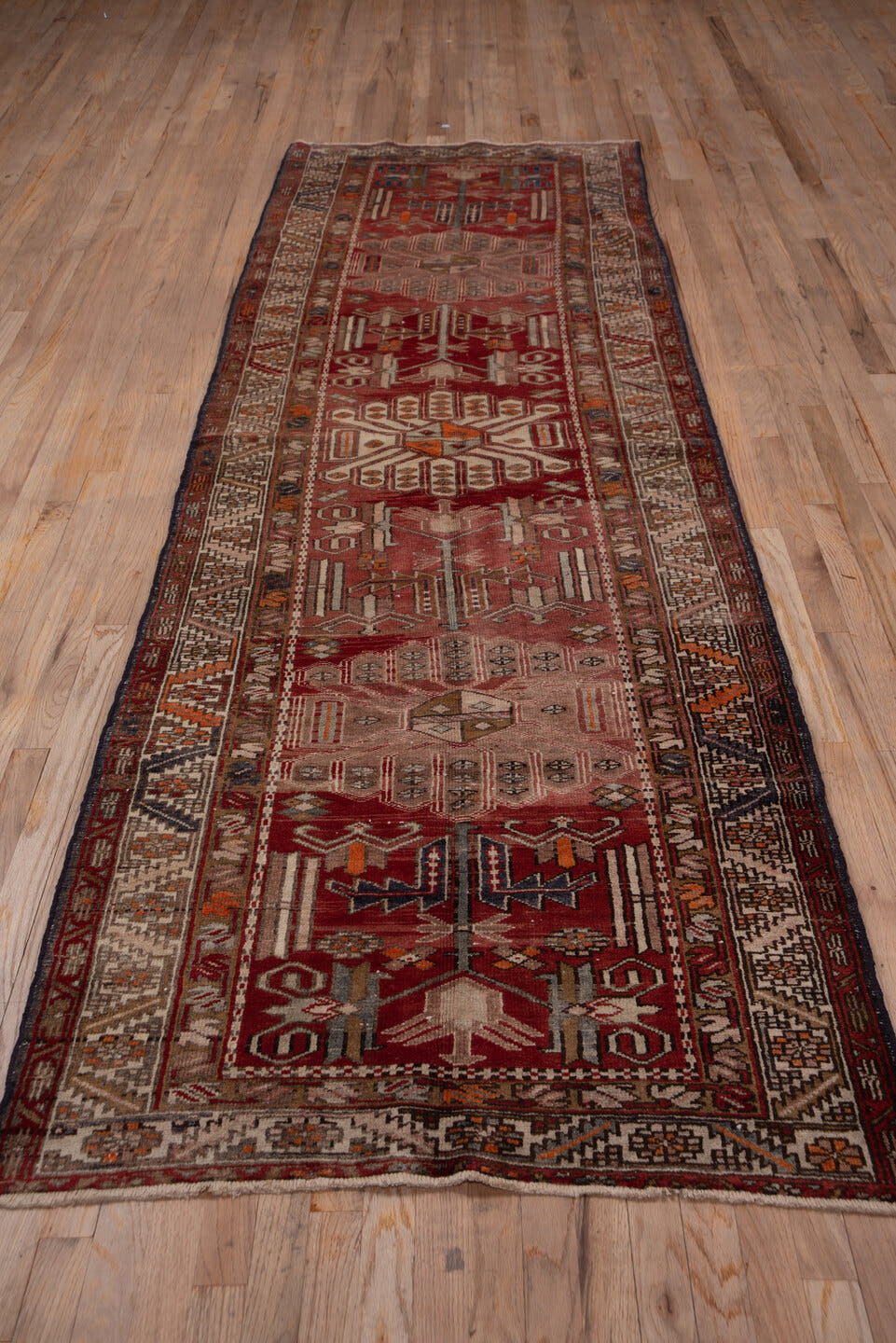 3' x 10' one-of-a-kind handmade vintage Heriz runner rug. Color palette: brick red, ivory, rose, rust, taupe, navy, orange
