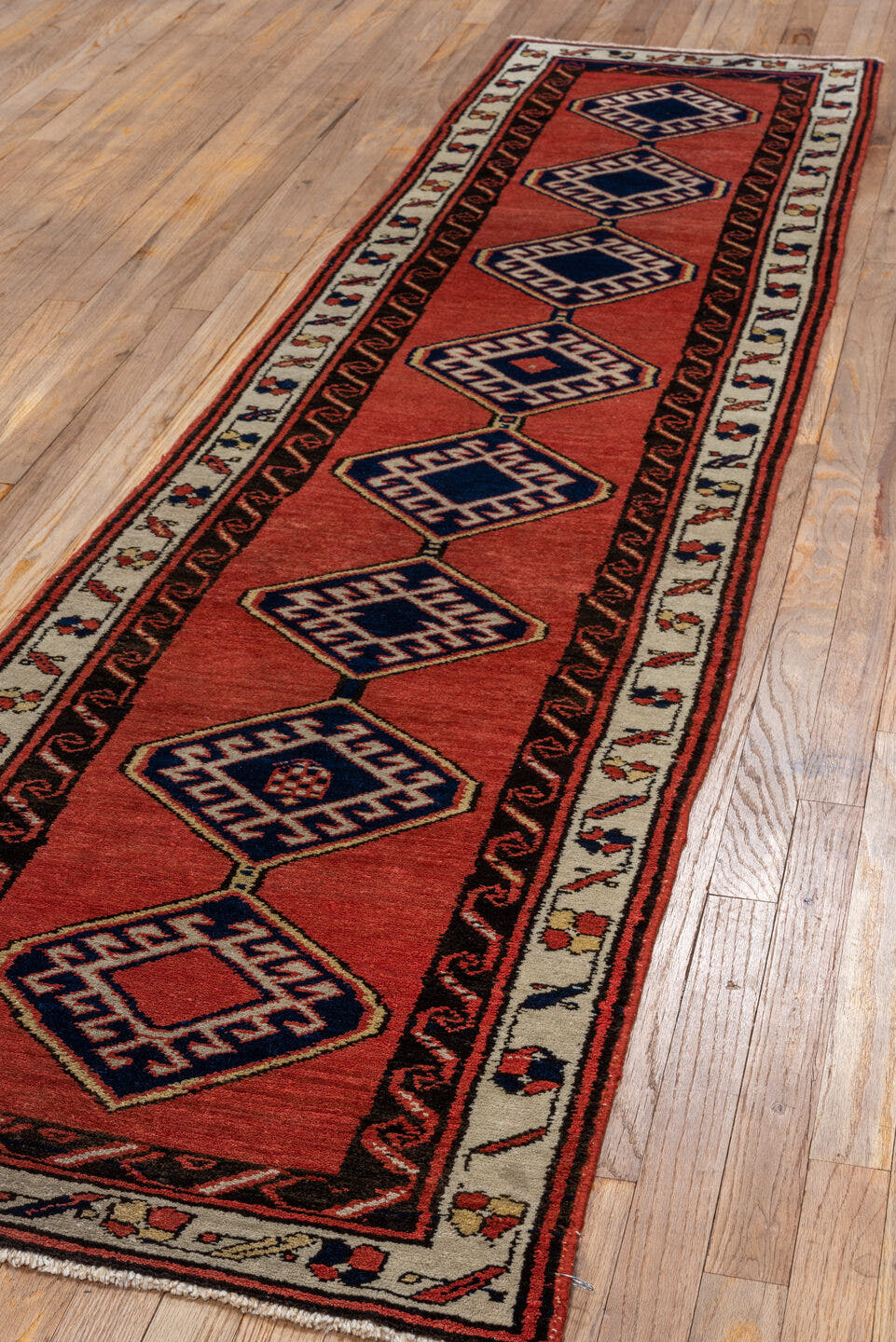 2' x 9' one-of-a-kind handmade antique Sarab runner rug. Color palette: terra cotta, ivory, navy, rust, charcoal, camel