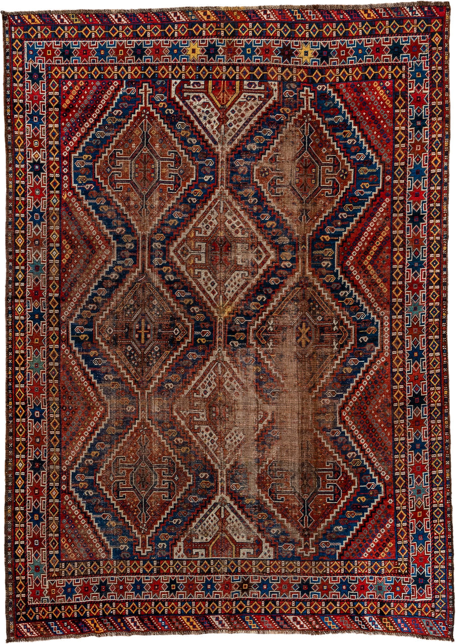 7' x 9' one-of-a-kind handmade vintage Shiraz rug. Color palette: rust, indigo, camel, ivory, crimson, navy, gold, brown
