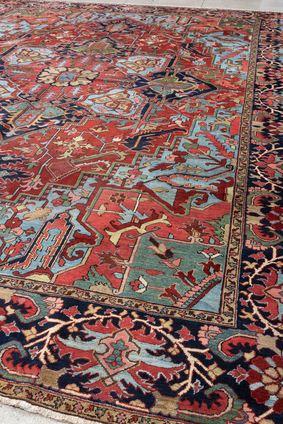 12' x 15' one-of-a-kind handmade antique Heriz oversize rug. Color palette: brick red, navy, turquoise, ivory, sage, coral