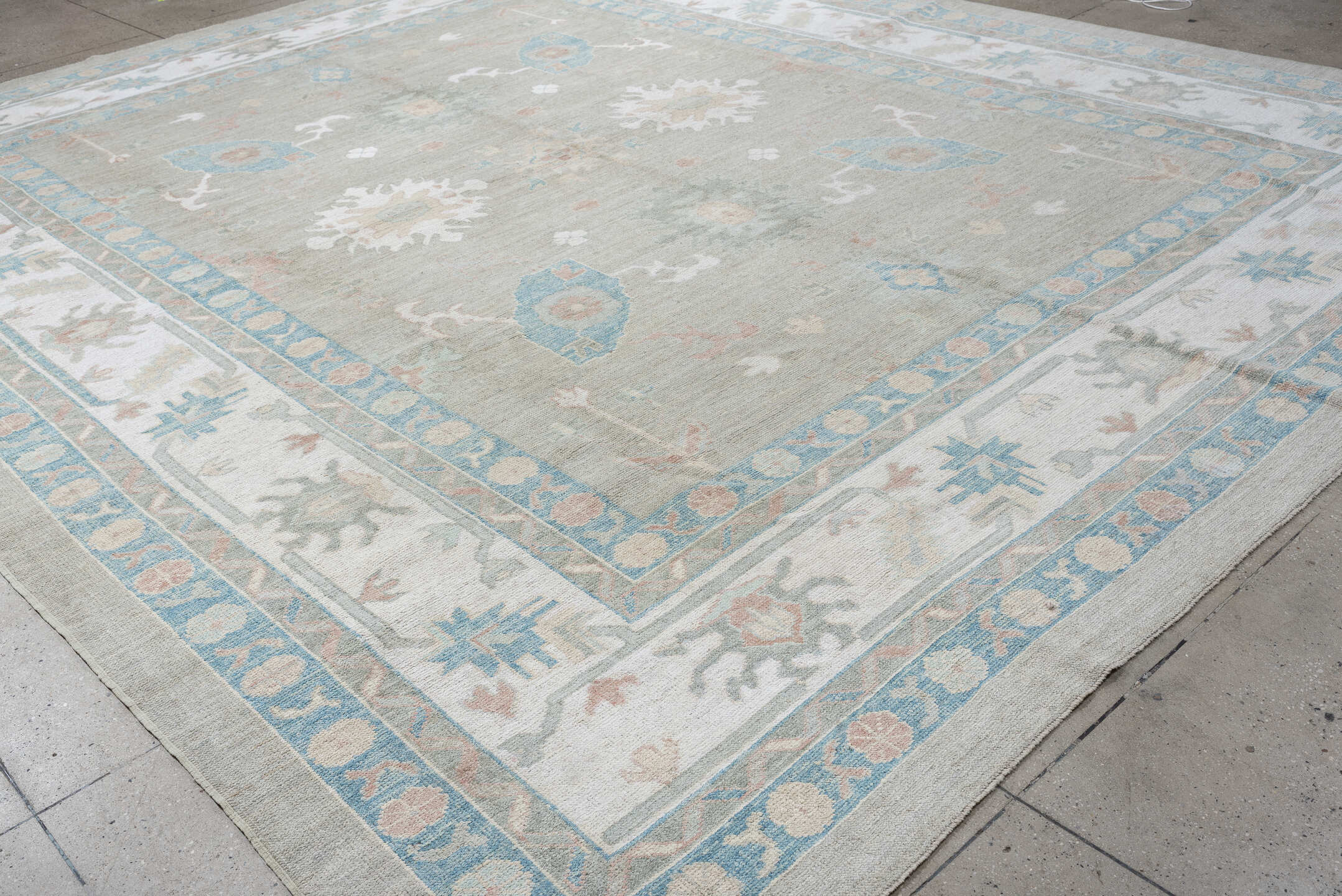 12' x 15' one-of-a-kind handmade vintage Oushak oversize rug. Color palette: pale gray, ivory, sky blue, peach, taupe, sage