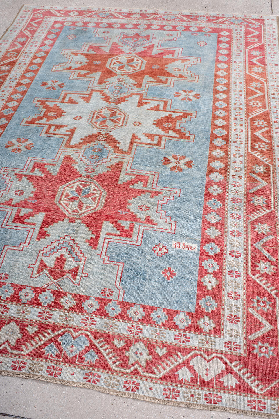 5' x 7' one-of-a-kind handmade antique Caucasian rug. Color palette: sky blue, coral, ivory, brick red, pale blue