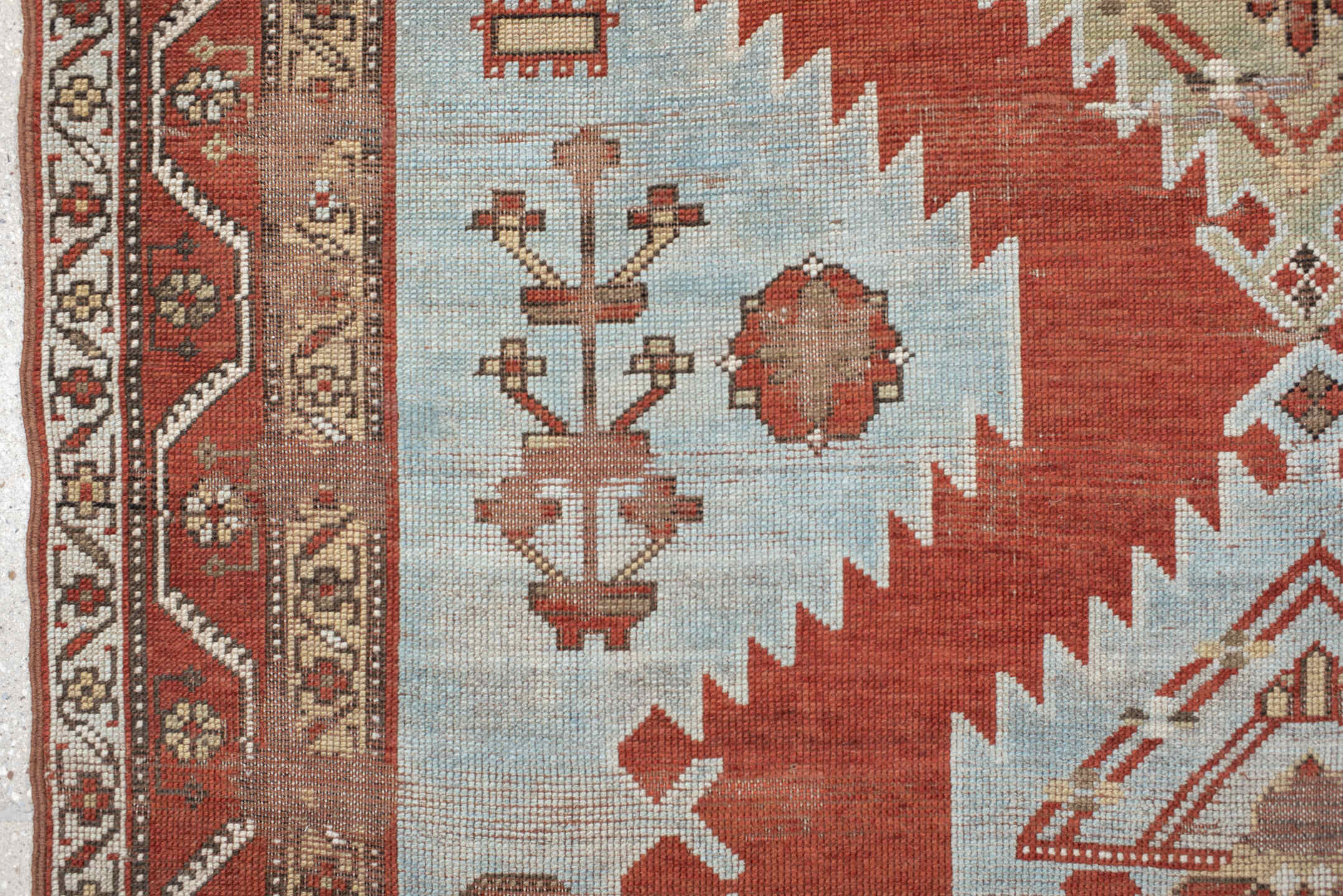 5' x 7' one-of-a-kind handmade antique Caucasian rug. Color palette: rust, sky blue, ivory, camel, taupe, crimson