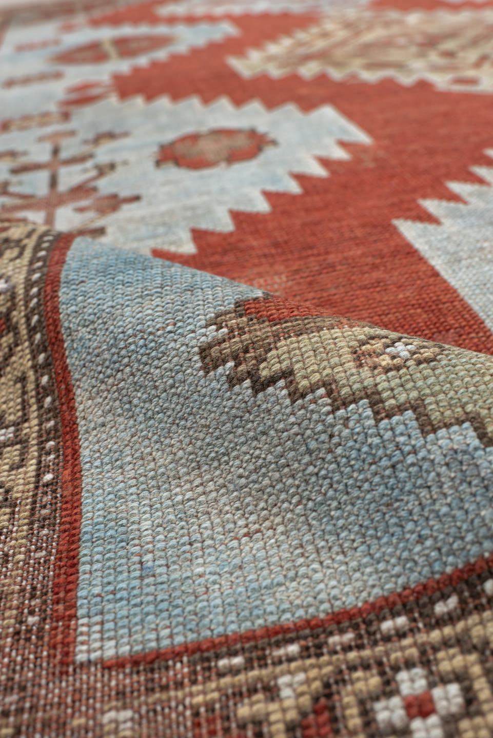 5' x 7' one-of-a-kind handmade antique Caucasian rug. Color palette: rust, sky blue, ivory, camel, taupe, crimson
