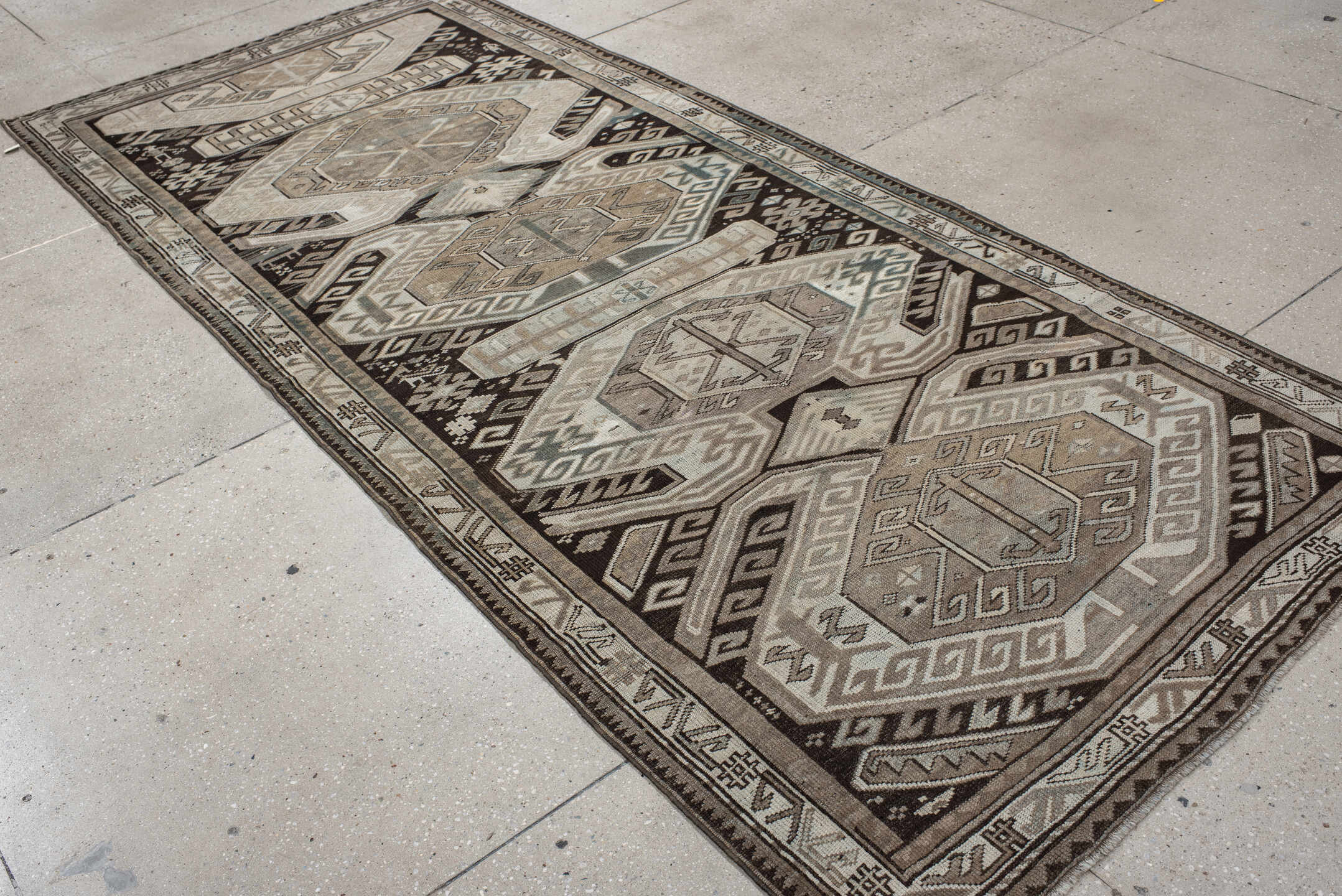 4' x 10' one-of-a-kind handmade antique Caucasian runner rug. Color palette: ivory, charcoal, taupe, brown, slate, gray