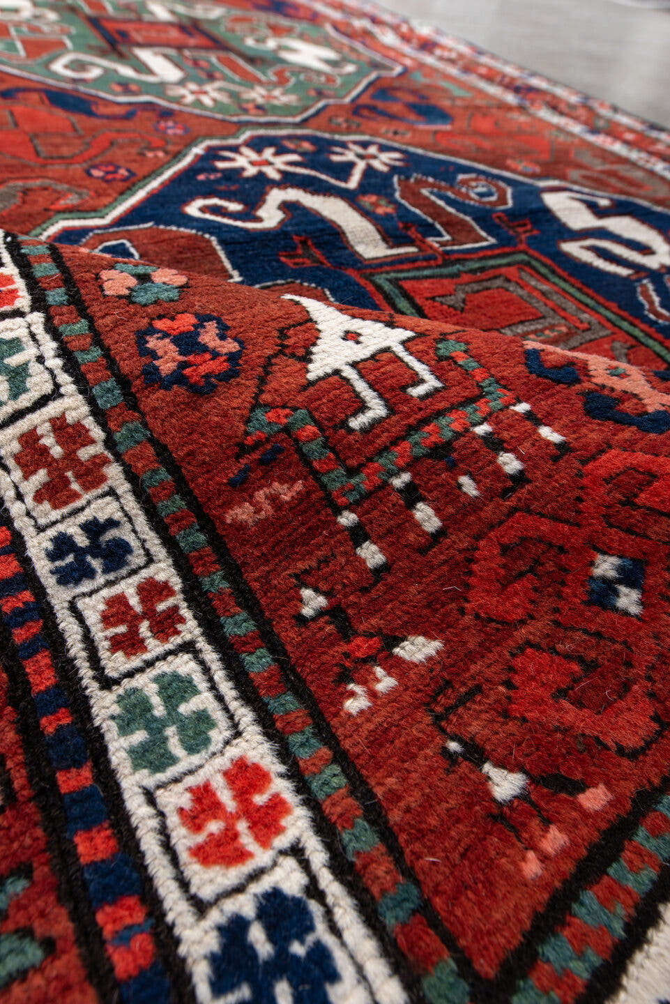4' x 8' one-of-a-kind handmade antique Kazak rug. Color palette: rust, navy, ivory, sage, crimson, teal, rose, terracotta