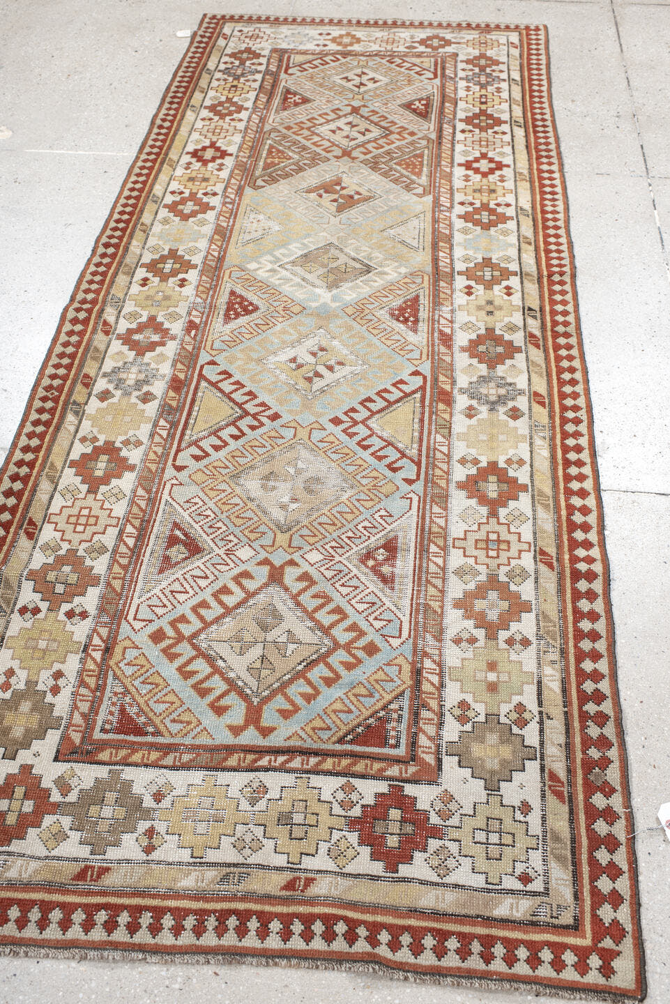 3' x 8' one-of-a-kind handmade antique Caucasian runner rug. Color palette: ivory, sky blue, rust, burgundy, camel, taupe