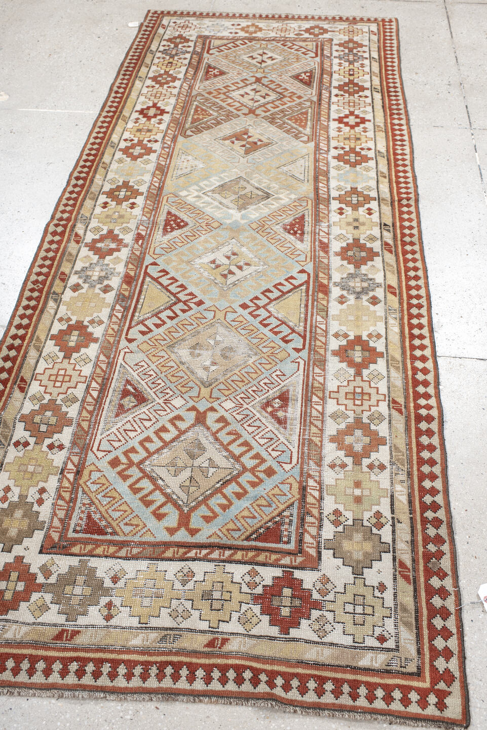 3' x 8' one-of-a-kind handmade antique Caucasian runner rug. Color palette: ivory, sky blue, rust, burgundy, camel, taupe
