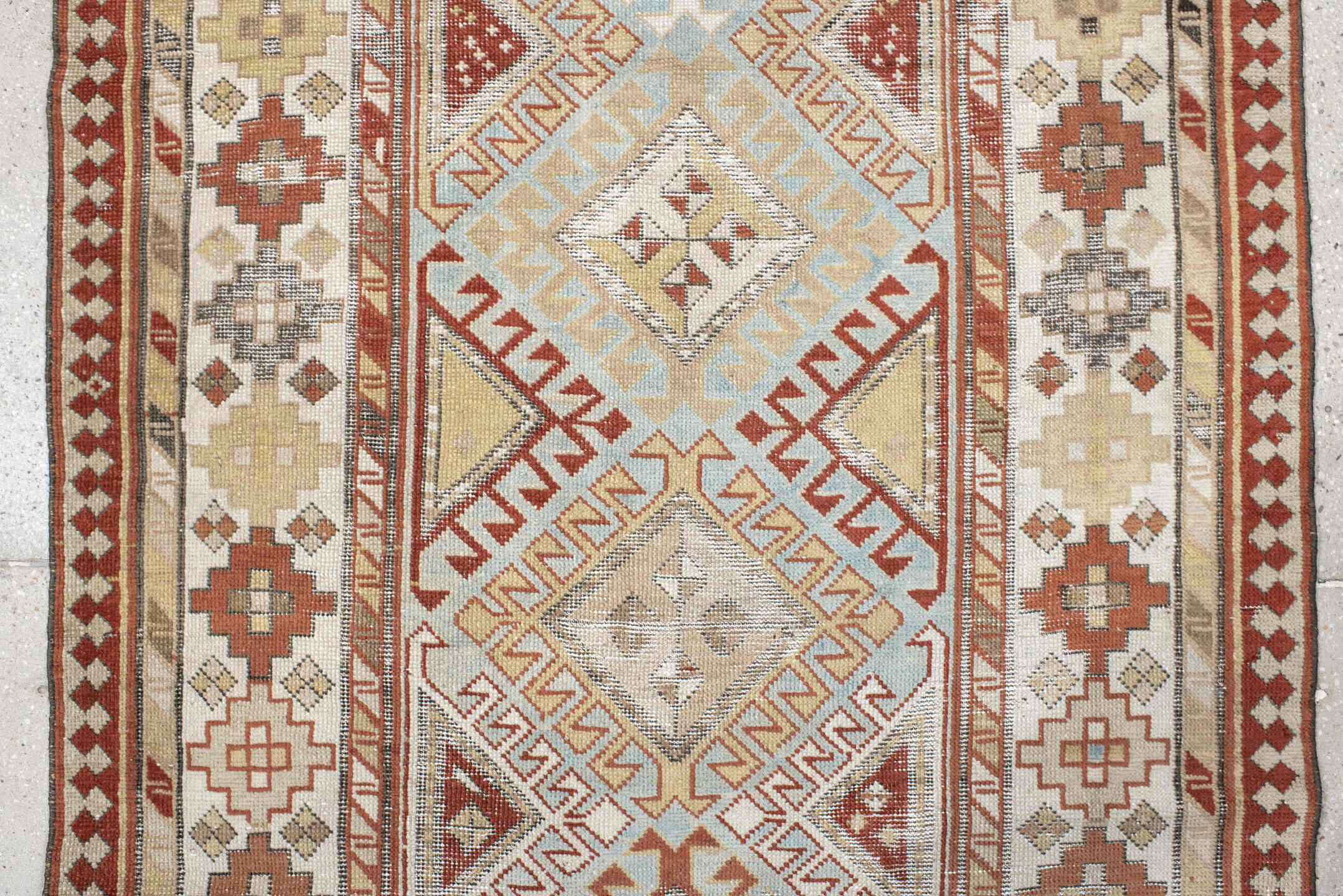 3' x 8' one-of-a-kind handmade antique Caucasian runner rug. Color palette: ivory, sky blue, rust, burgundy, camel, taupe