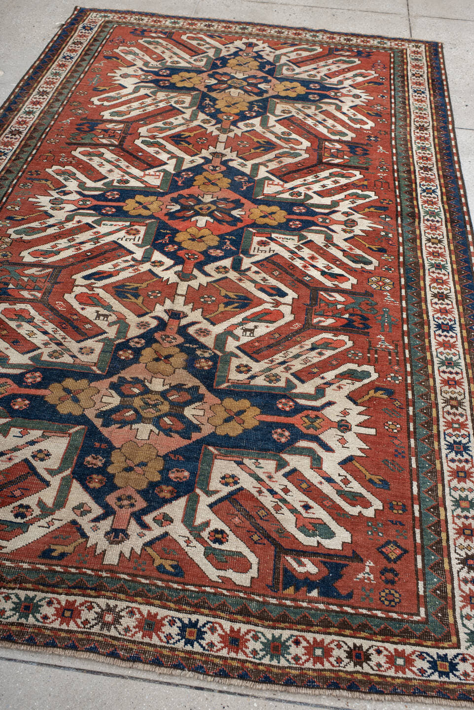 5' x 8' one-of-a-kind handmade antique Kazak medium size rug. Color palette: rust, ivory, navy, sage, gold, crimson, rose